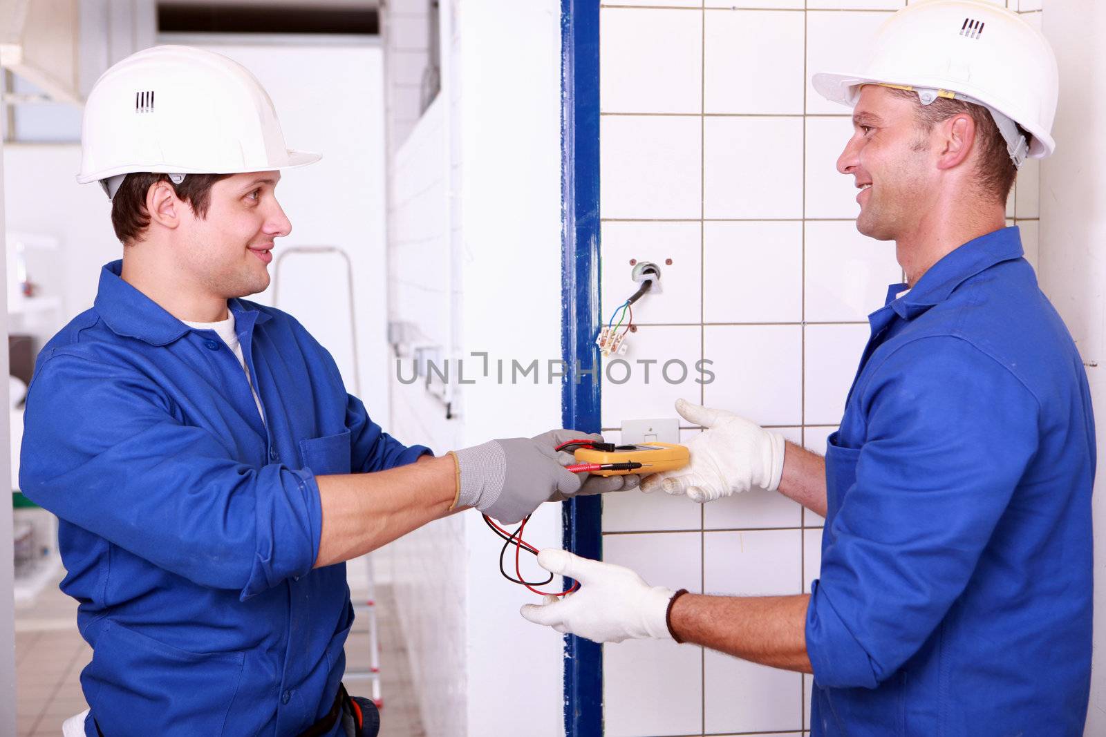 Two male electrical engineers checking power supply