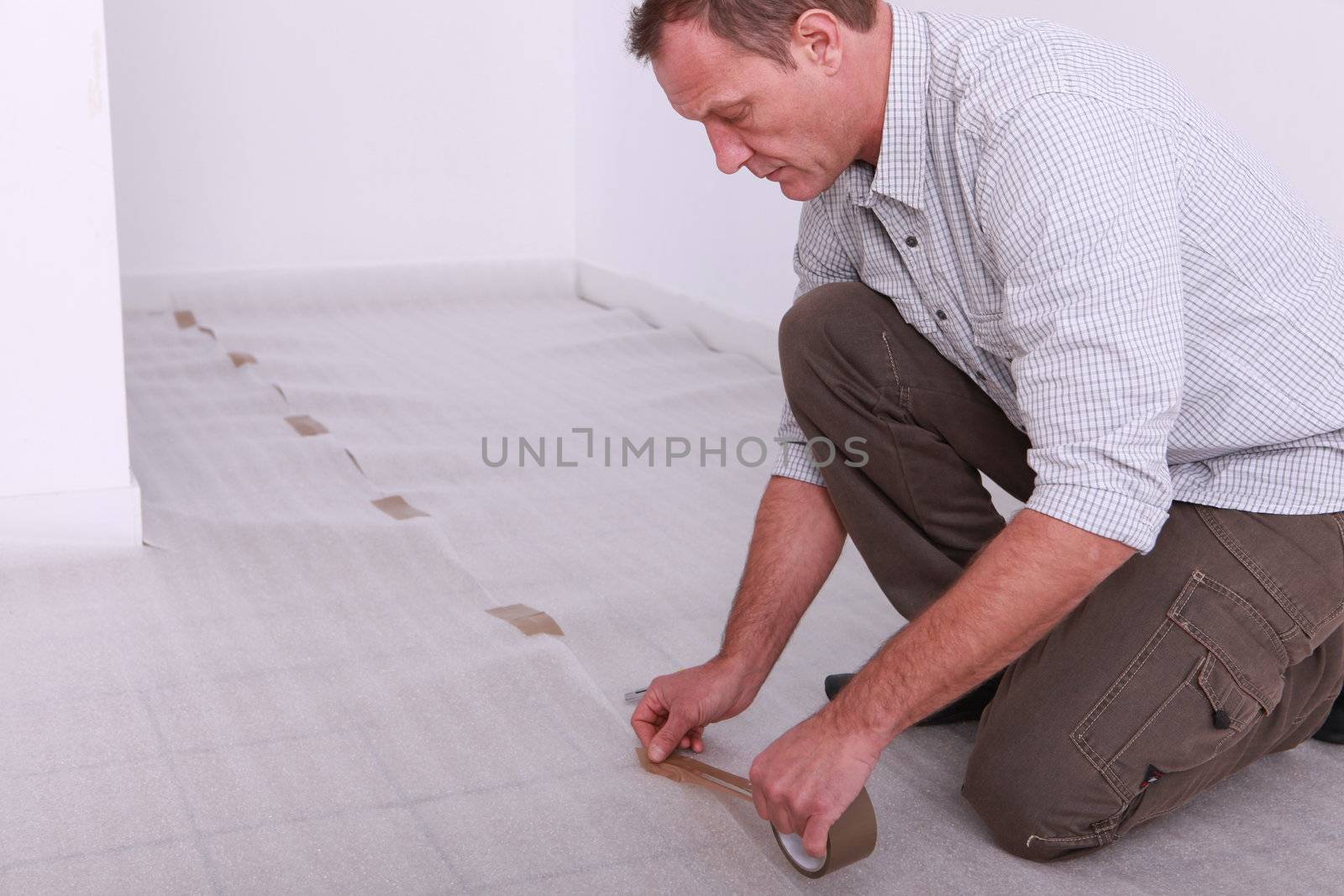 Man taping down underlay