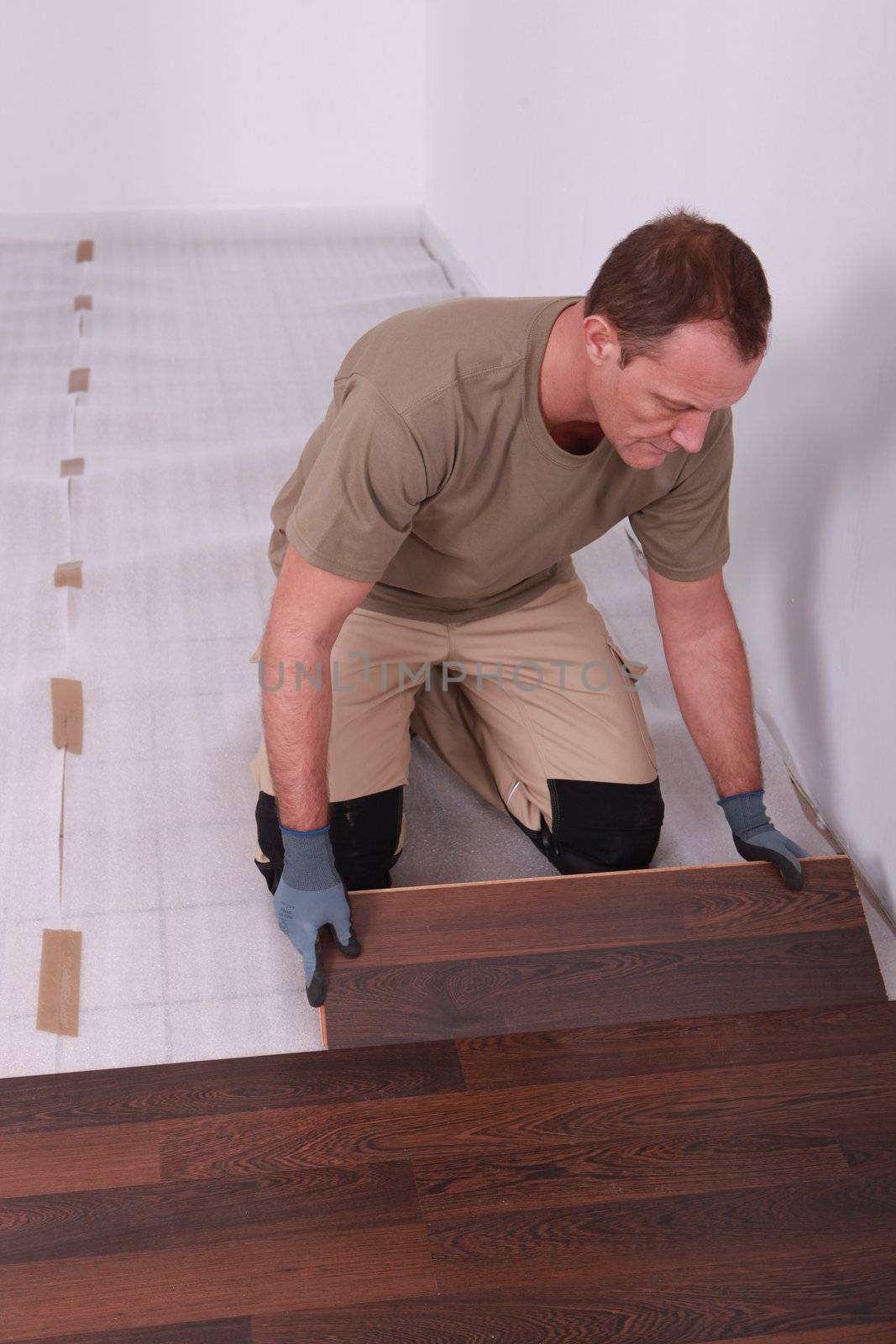 Handy-man laying wooden flooring