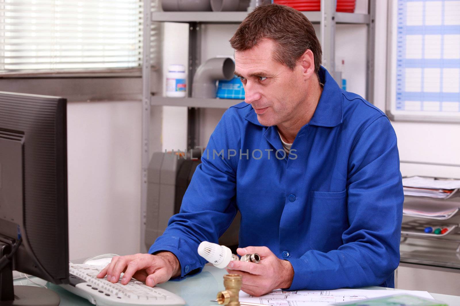 Plumber's merchant looking up the details for a thermostatic valve on the computer