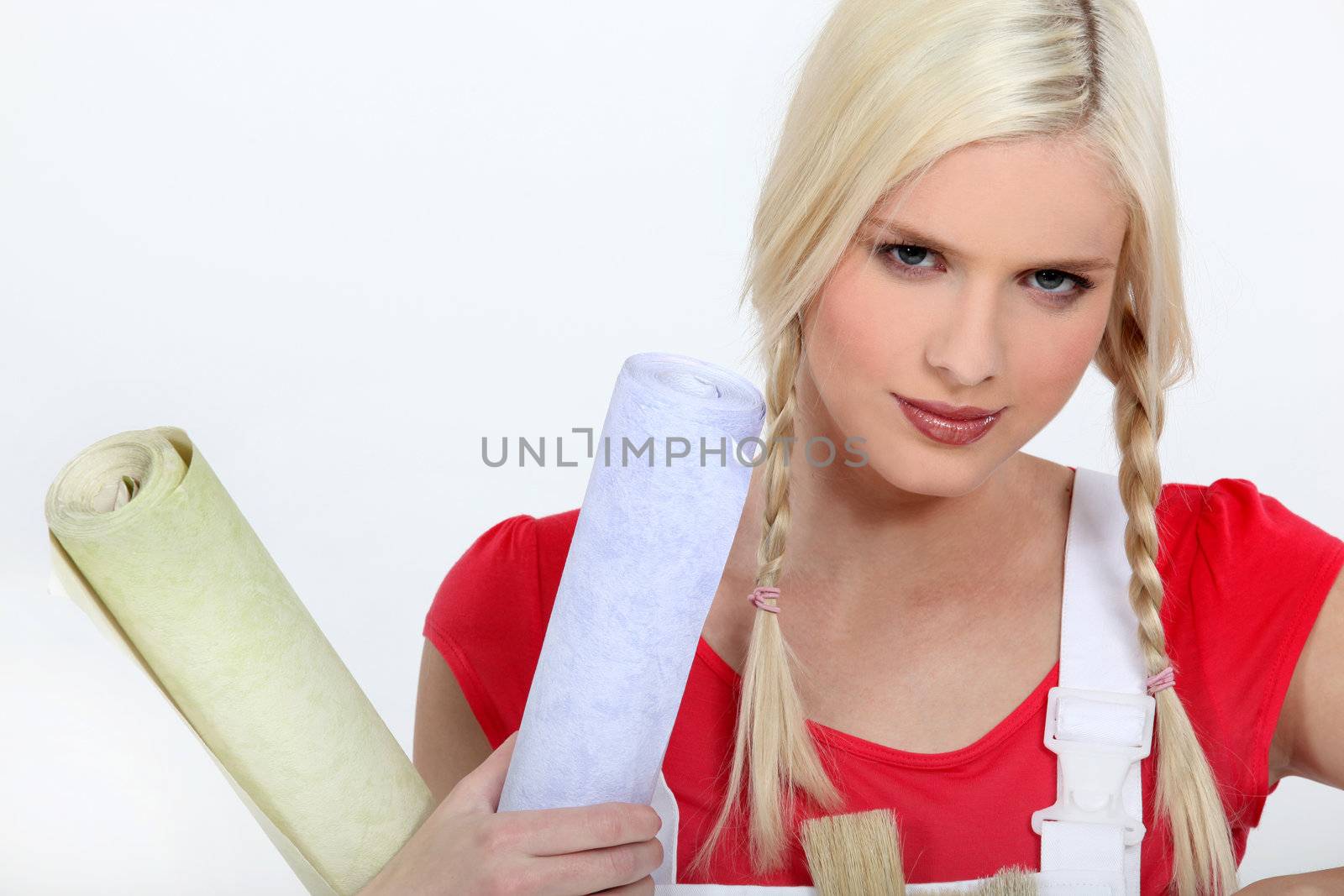 Blond woman holding rolls of wallpaper