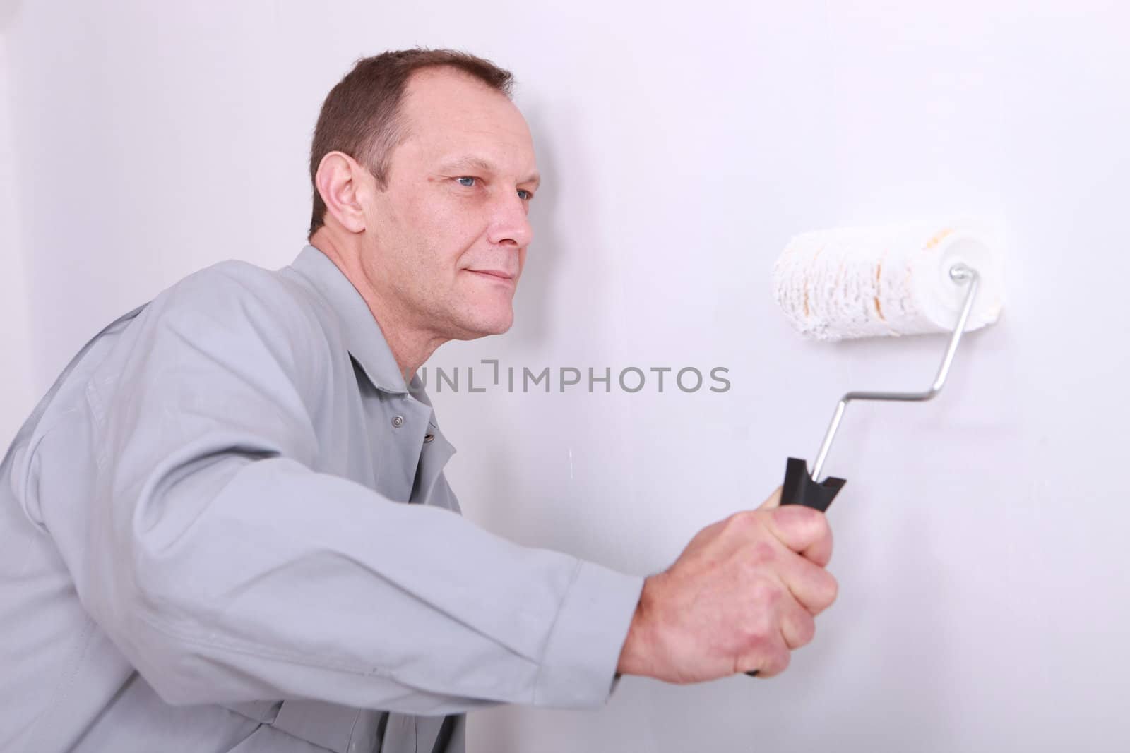 Decorator painting a wall white