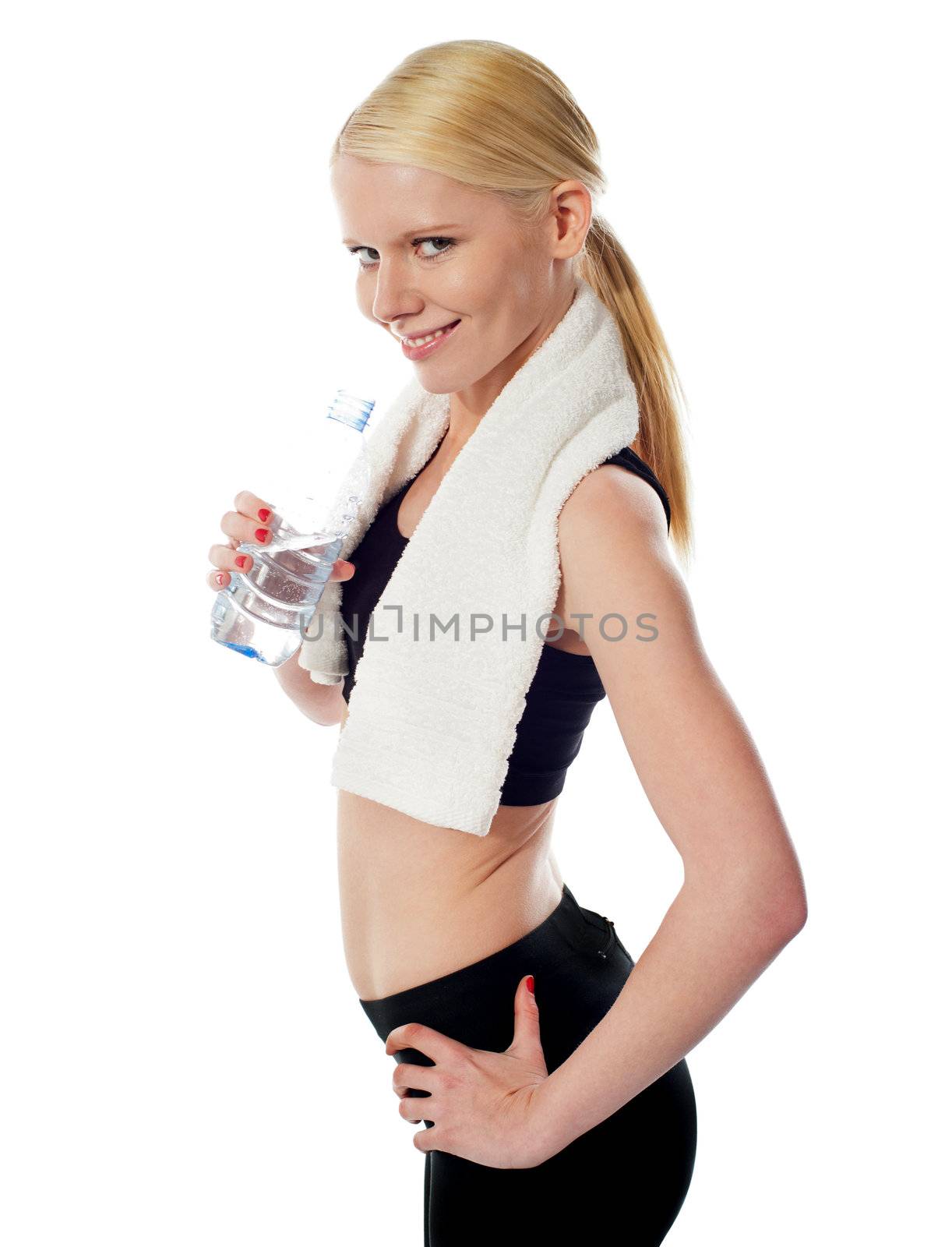 Fit female athlete holding a bottle of water with white towel around her neck