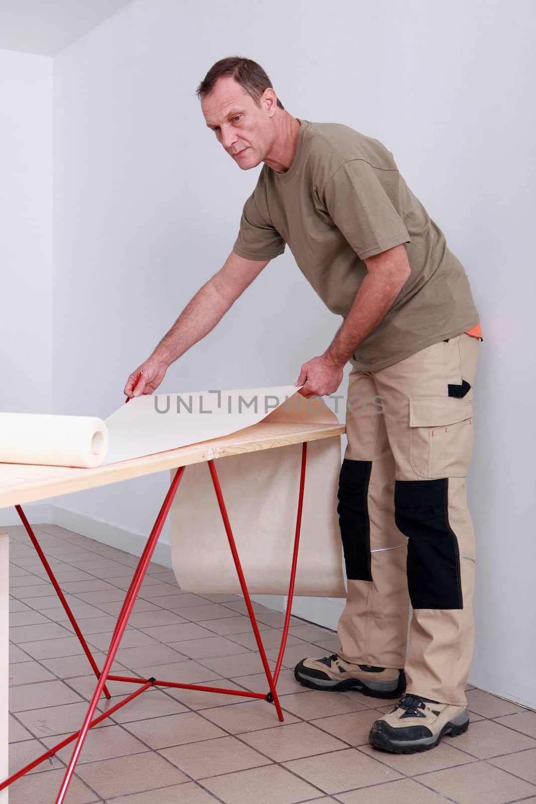Man hanging wallpaper