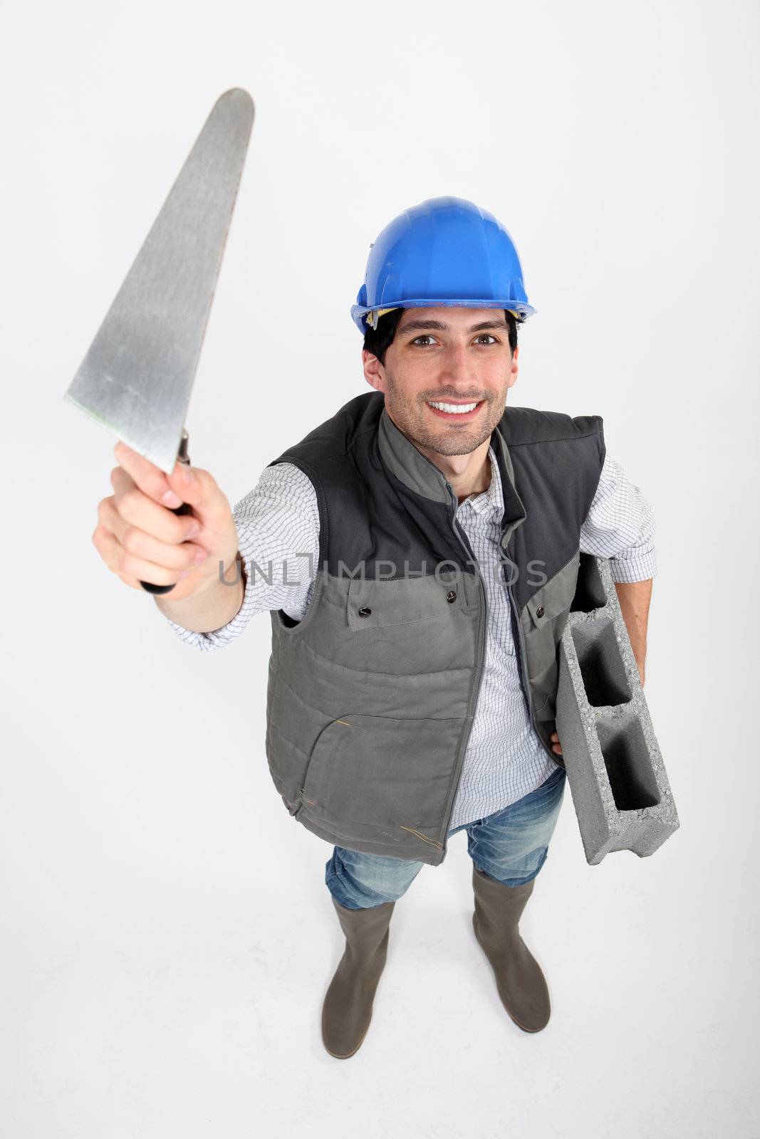 Bricklayer with trowel and cement block
