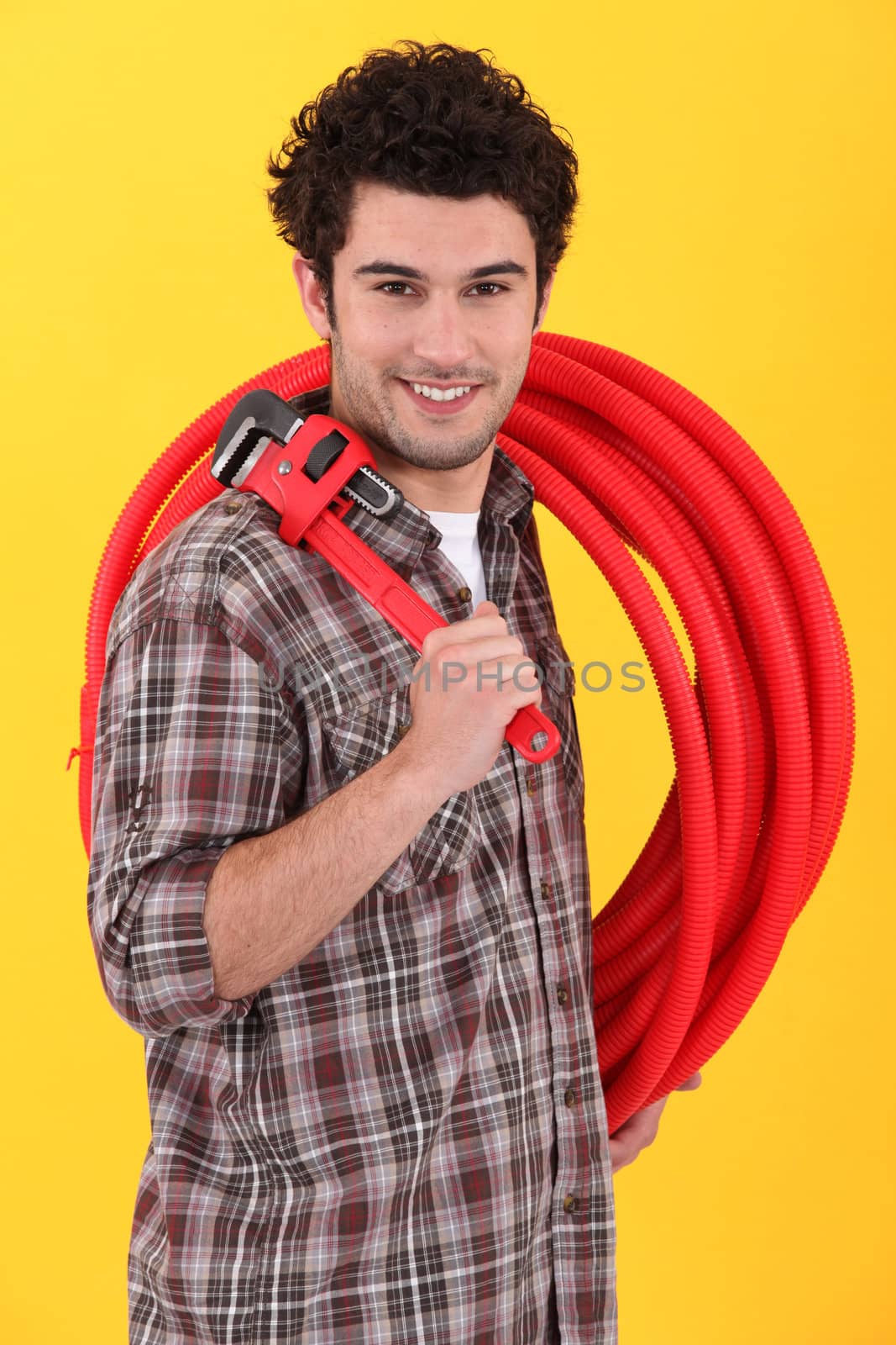 Plumber holding wrench and length of plastic pipe