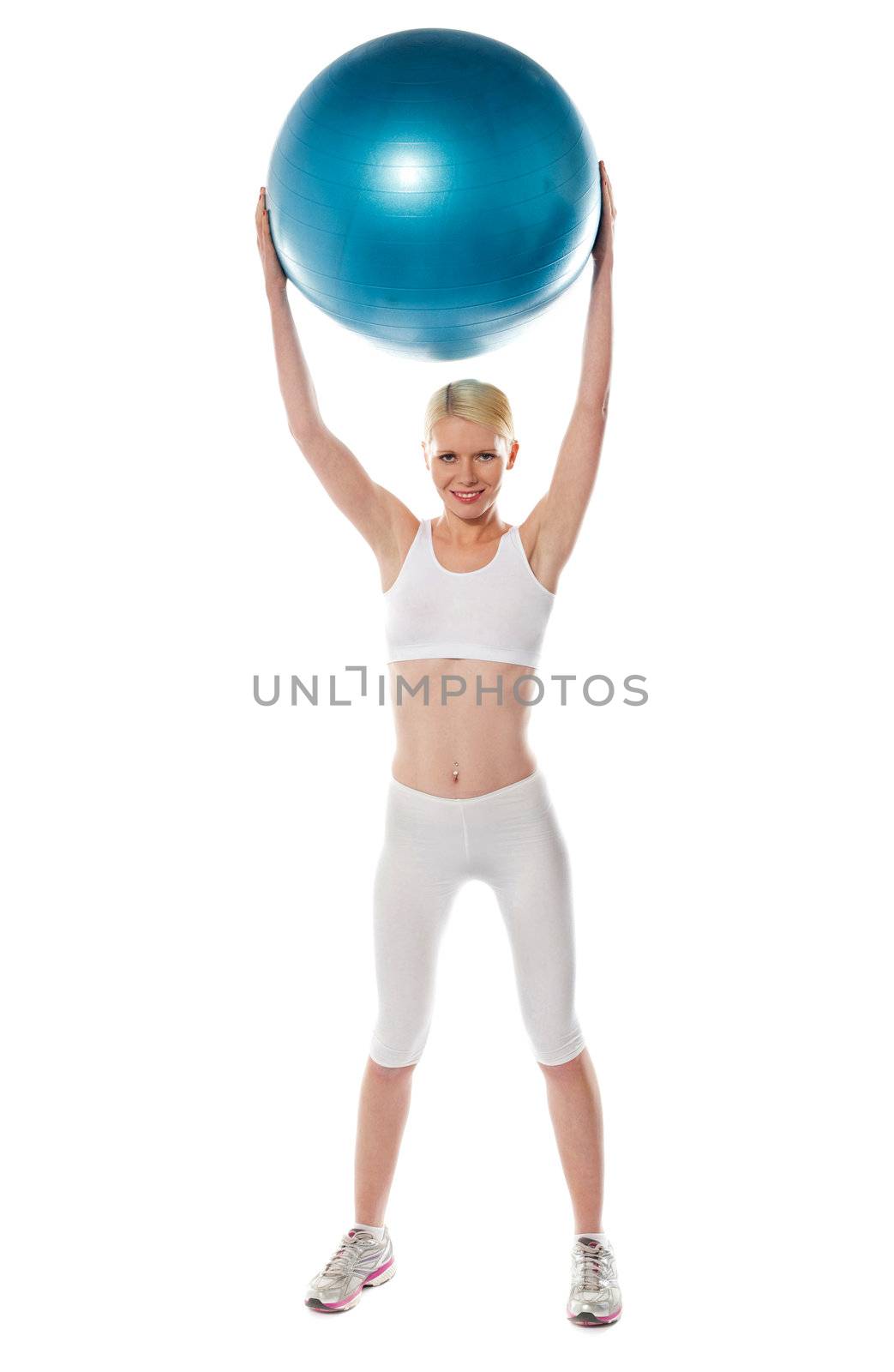 Sporty woman holding ball over her head by stockyimages