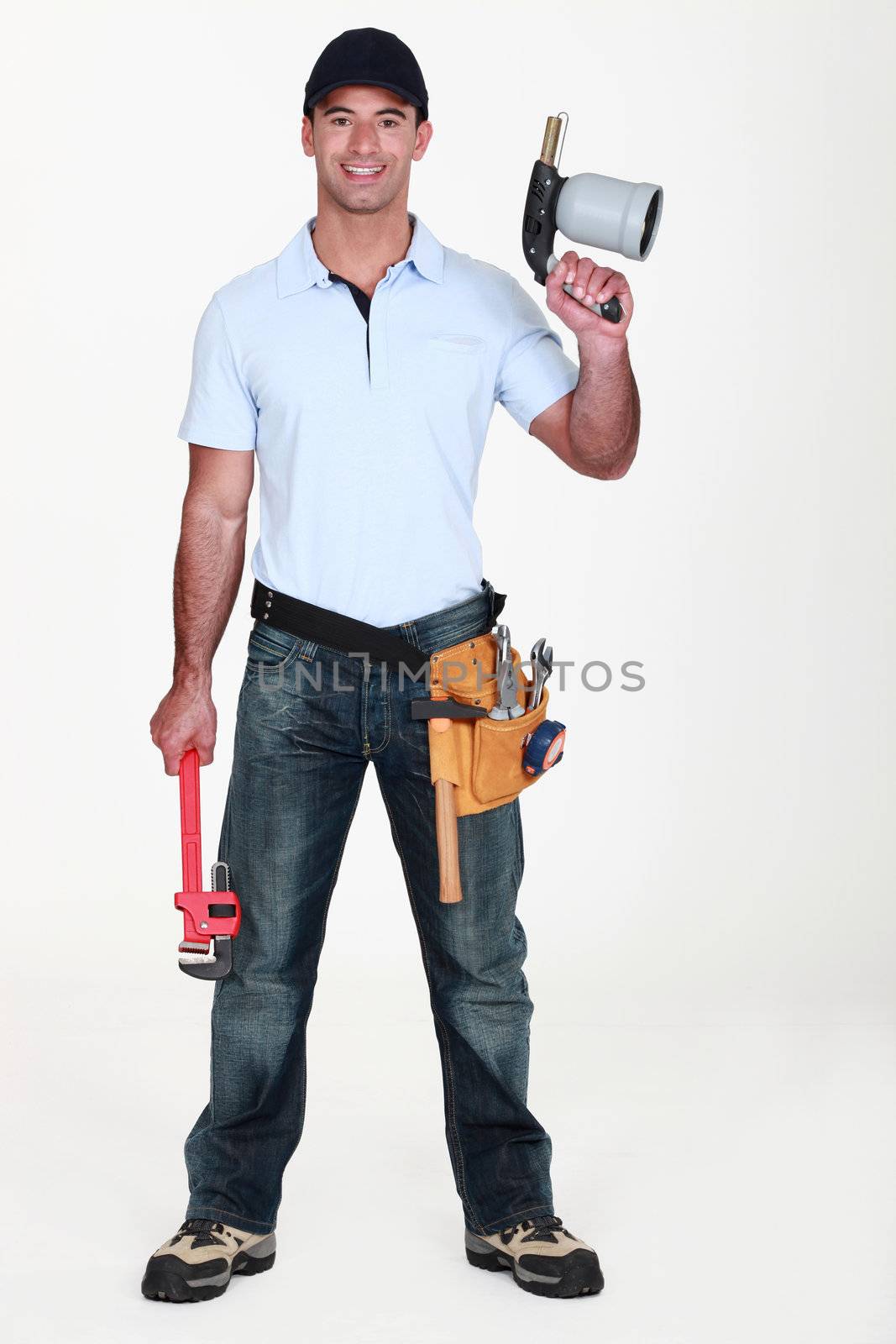A plumber holding a wielding torch and a wrench.