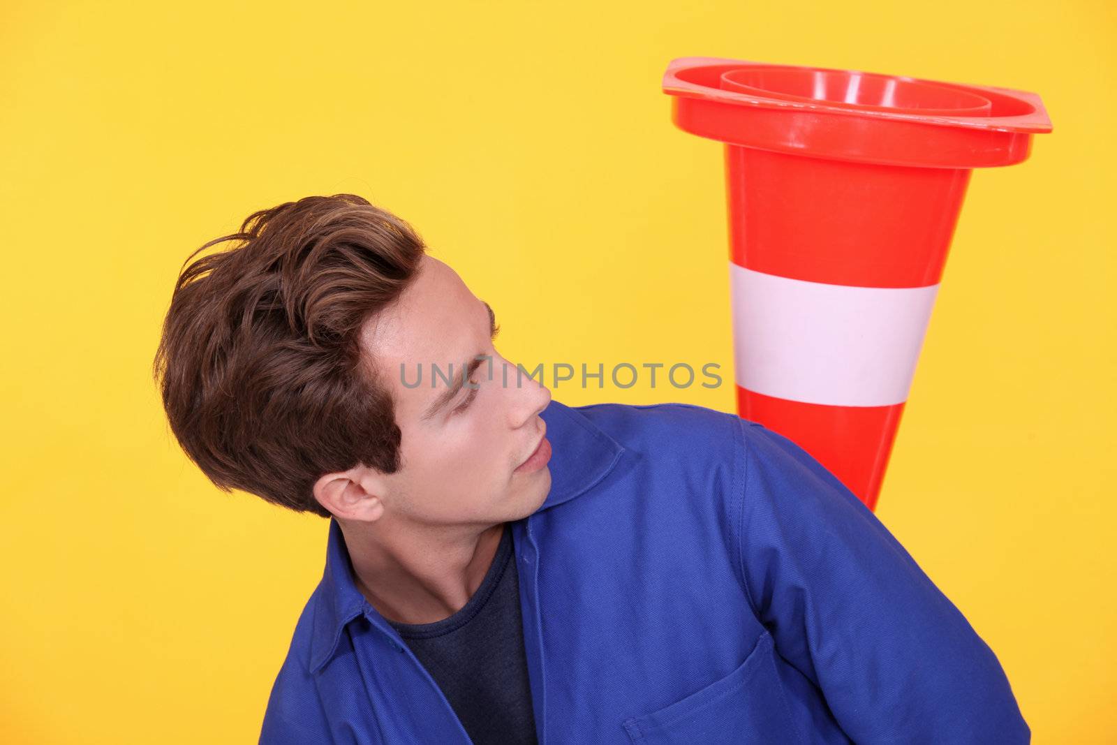 Tradesman playing with a traffic cone