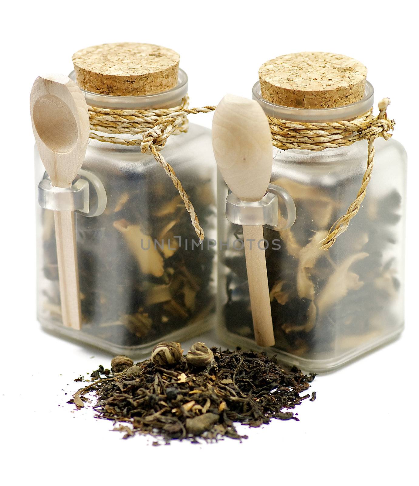 Tea leaves in transparent parisons with wooden spoon by zhekos