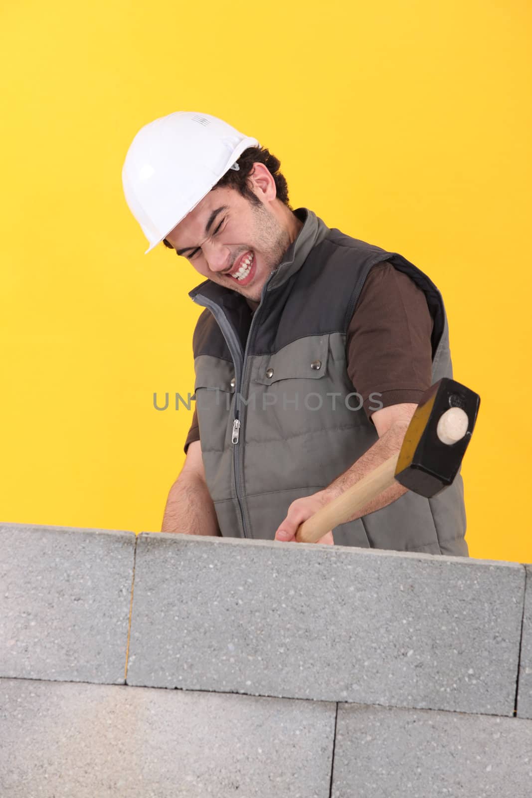 Worker hitting a wall with a sledgehammer