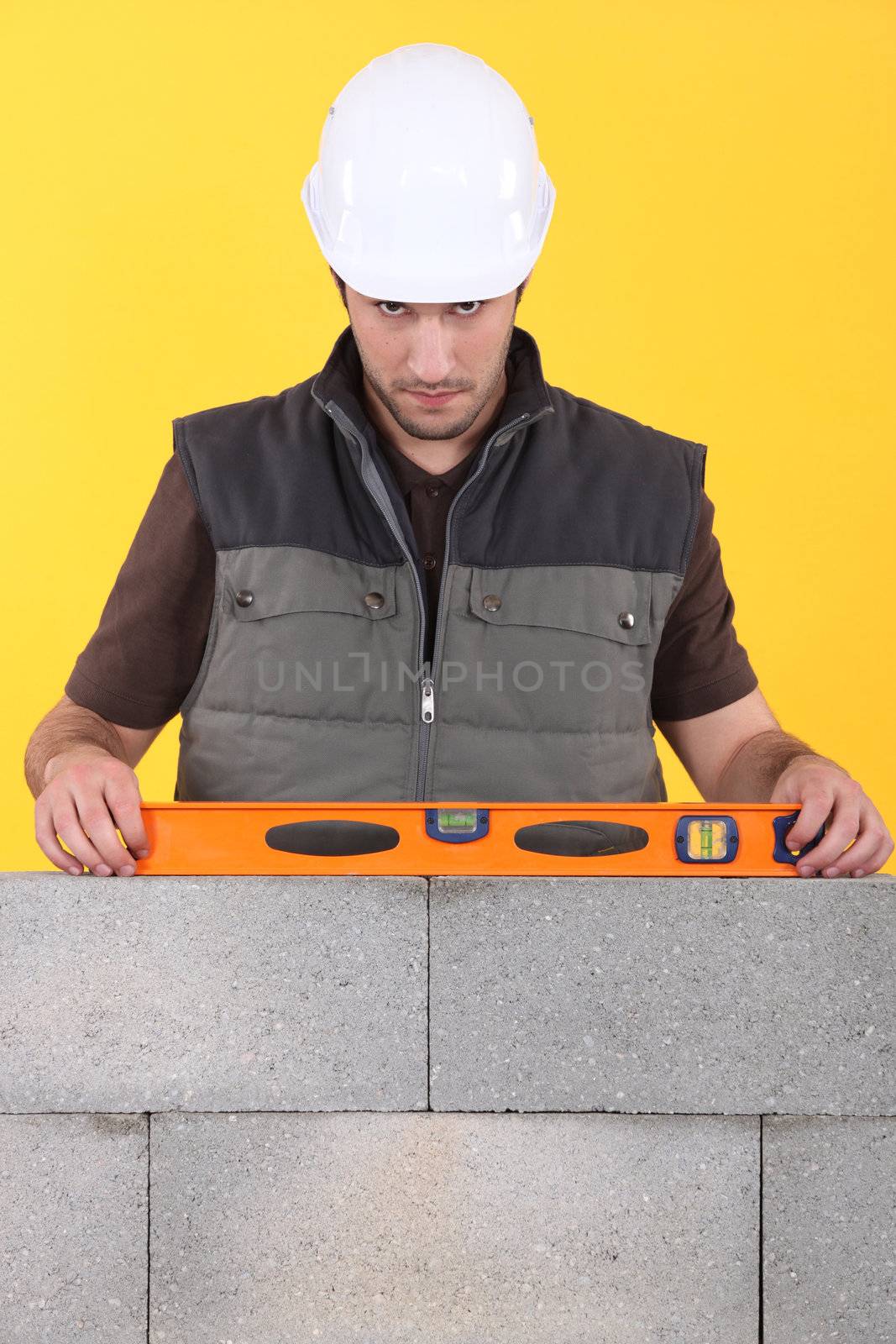 Construction worker measuring an angle with a spirit level