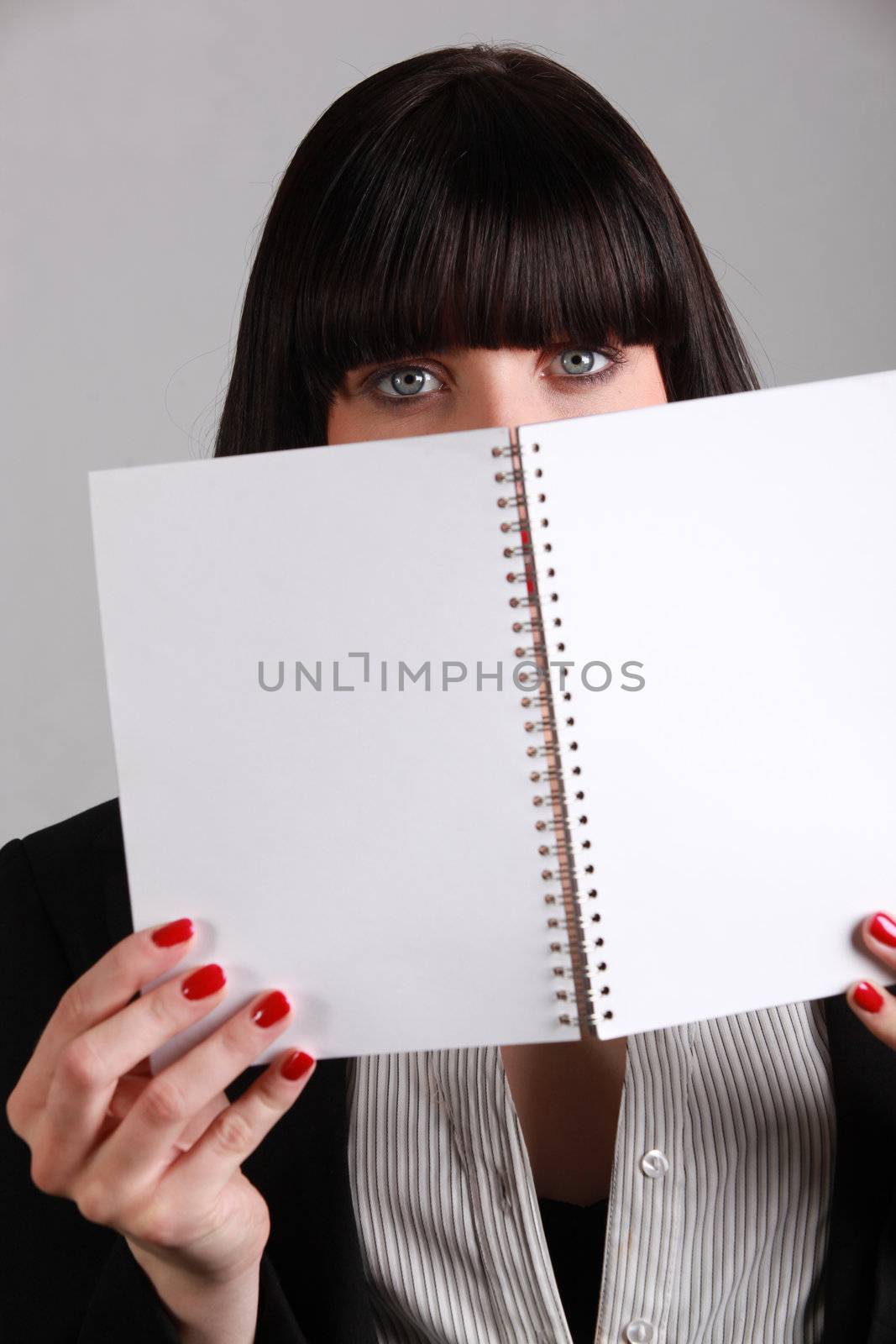 woman hiding behind wire-bound notebook