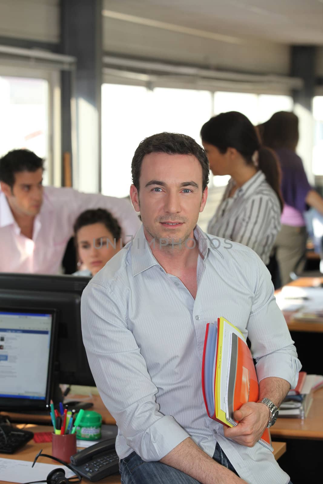 Man sitting on a desk with files