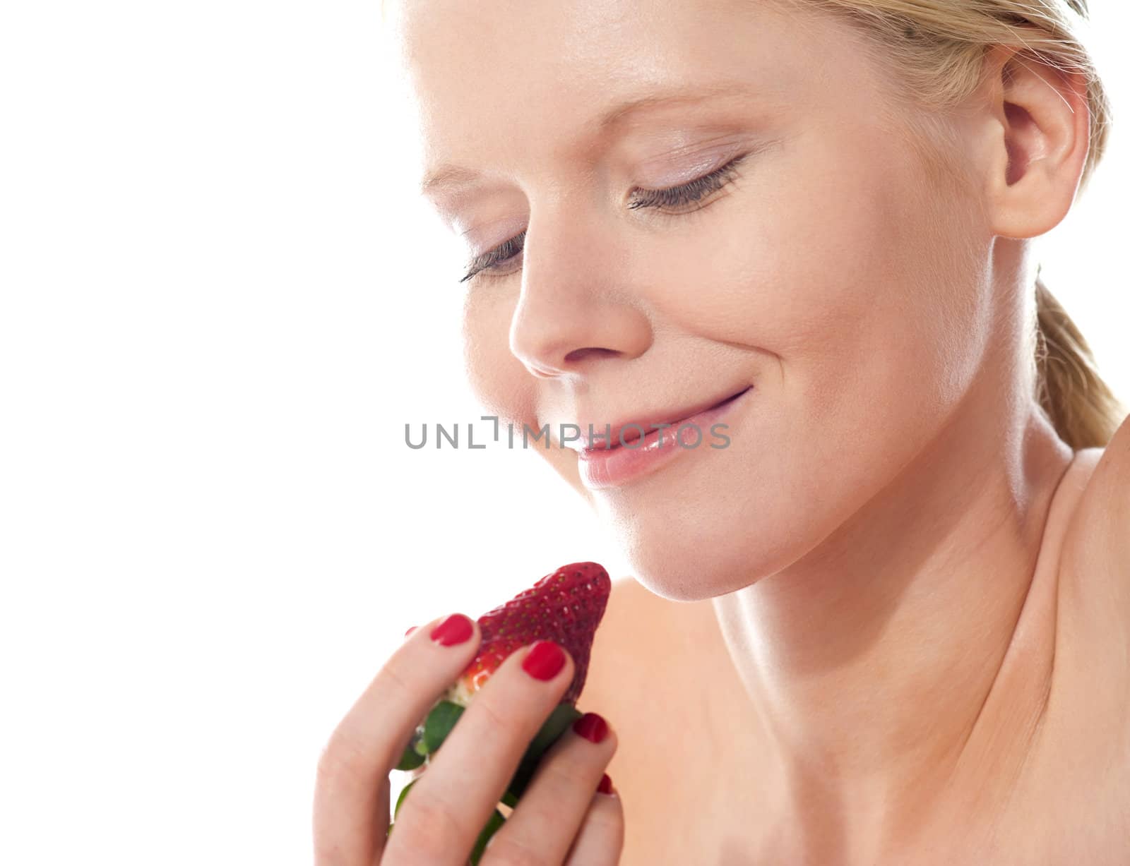 Young lady holding a strawberry by stockyimages
