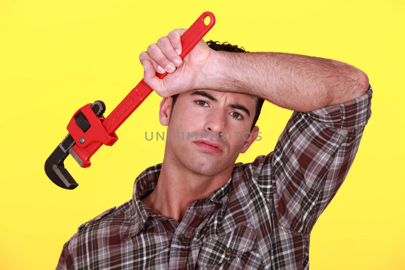 Tired worker holding wrench