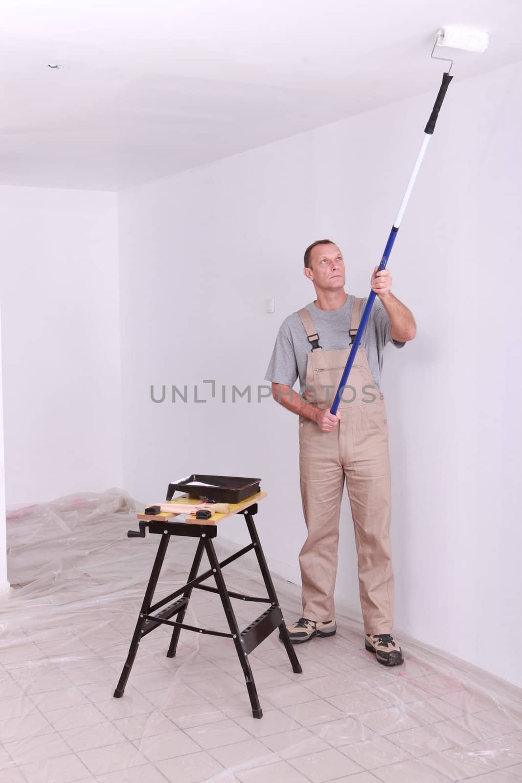 Man painting a room white
