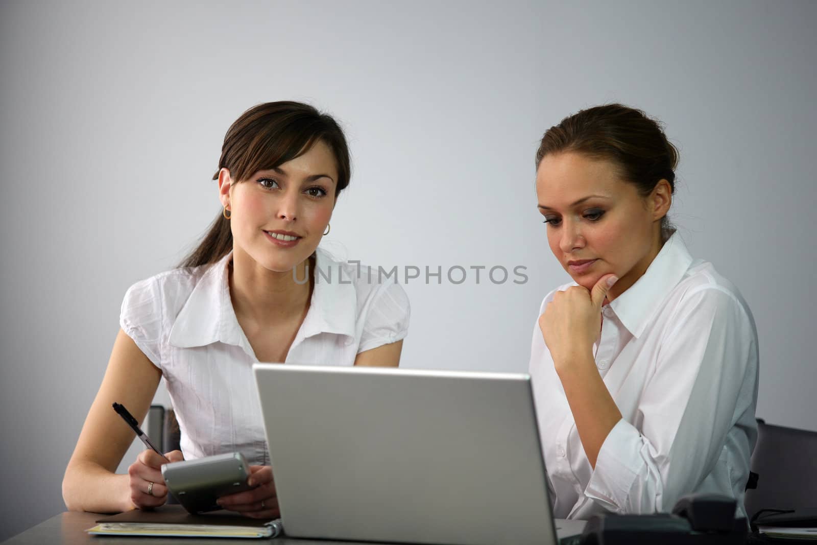 Clerical workers in front of a laptop