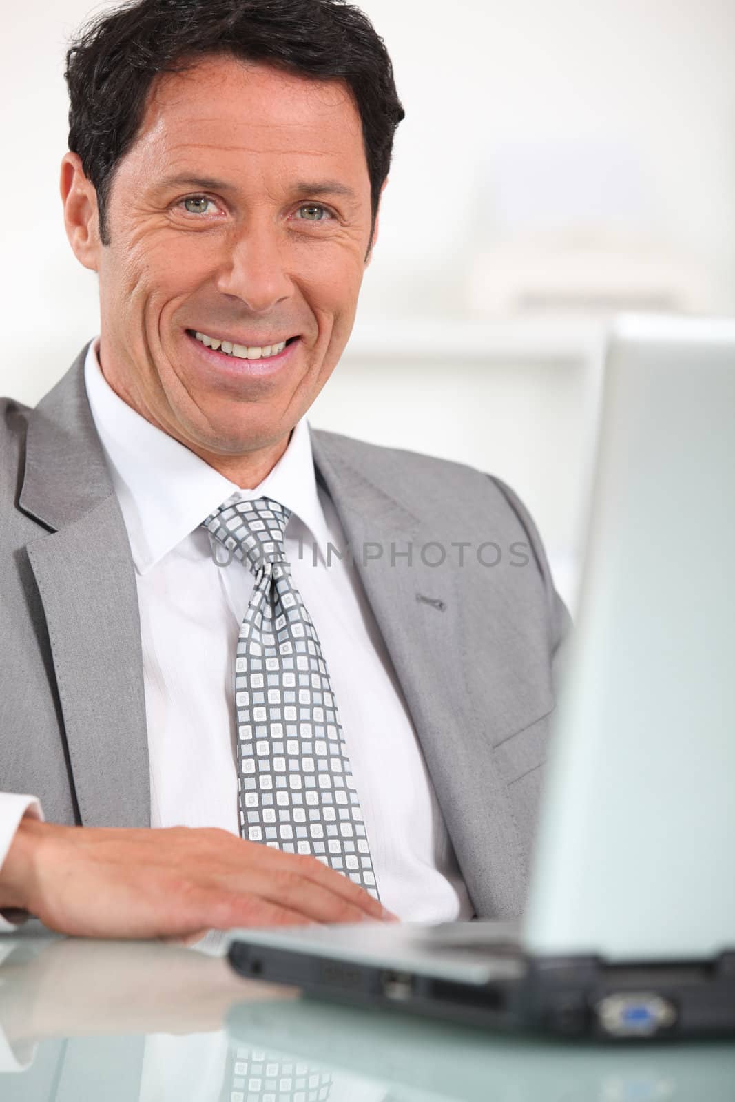 Satisfied businessman in front of laptop computer
