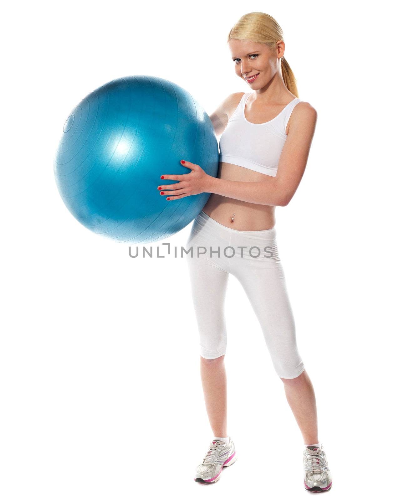 Healthy fit female athlete standing with big ball on her waist