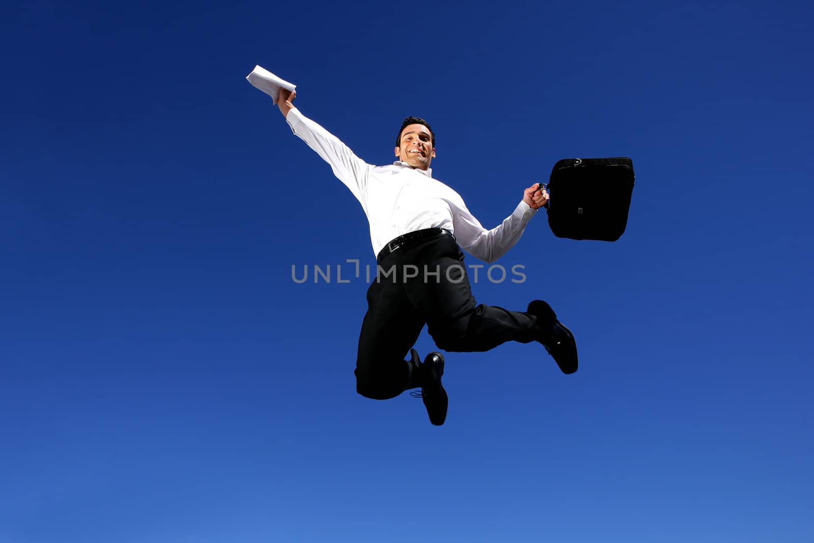 Successful businessman jumping in the air