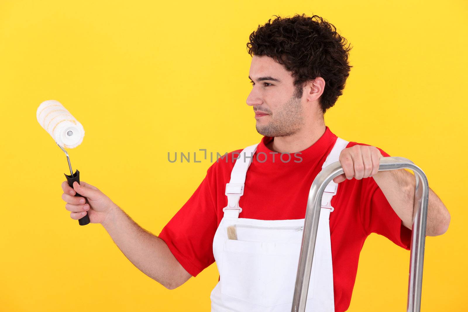 Man with step-ladder using paint-roller