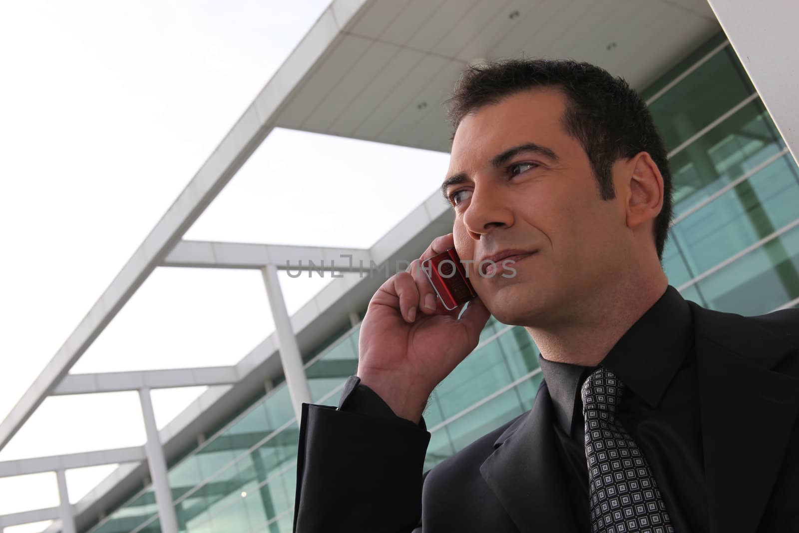 Businessman stood outside office telephoning