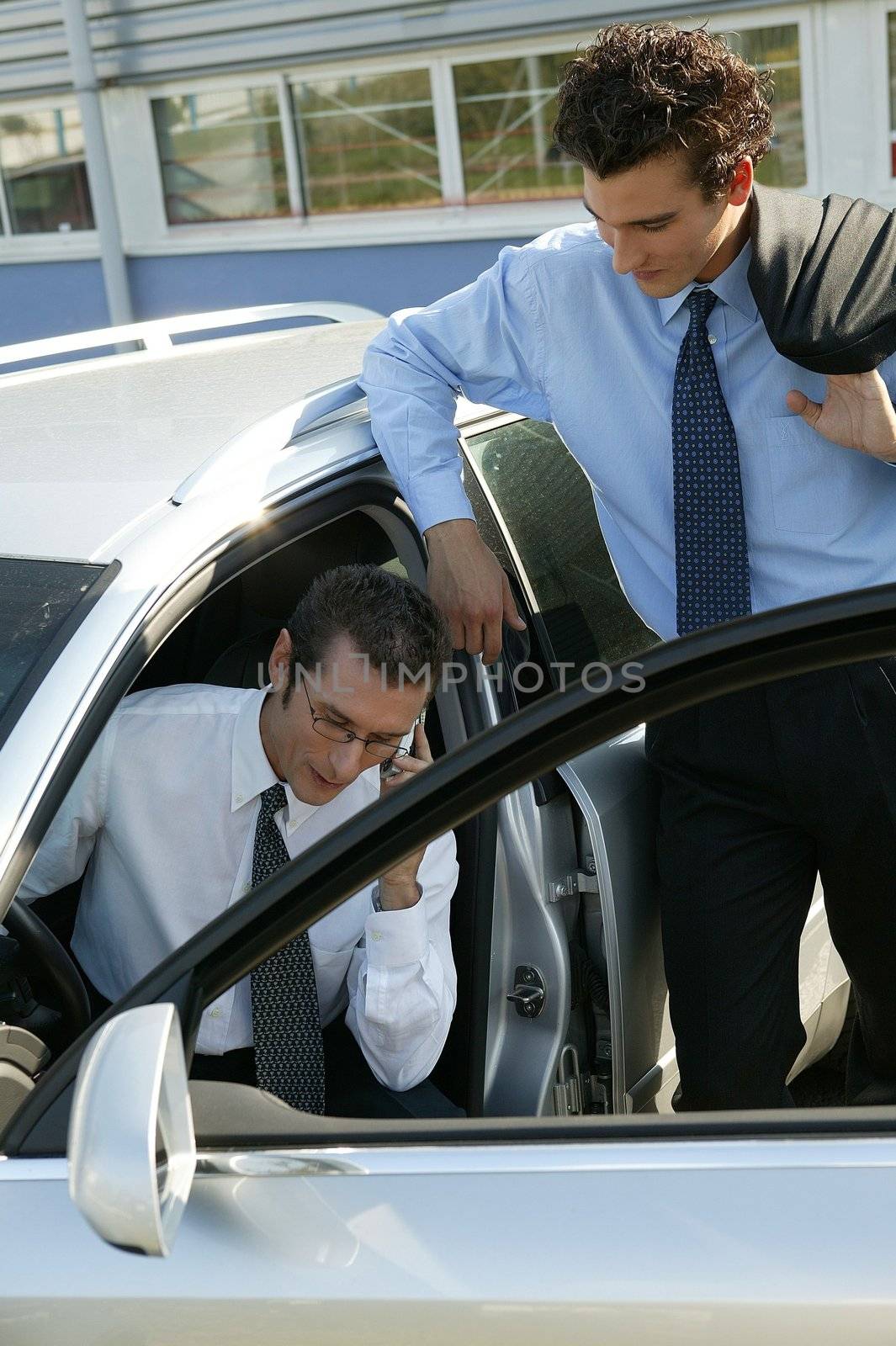 Businessmen by a car by phovoir