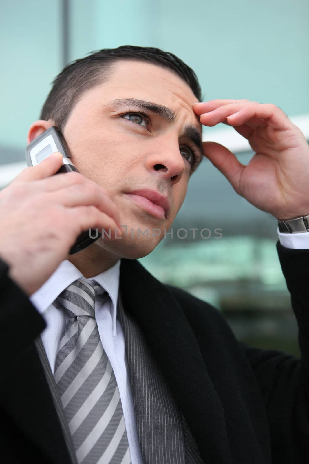 close-up shot of young businessman on the phone looking preoccupied