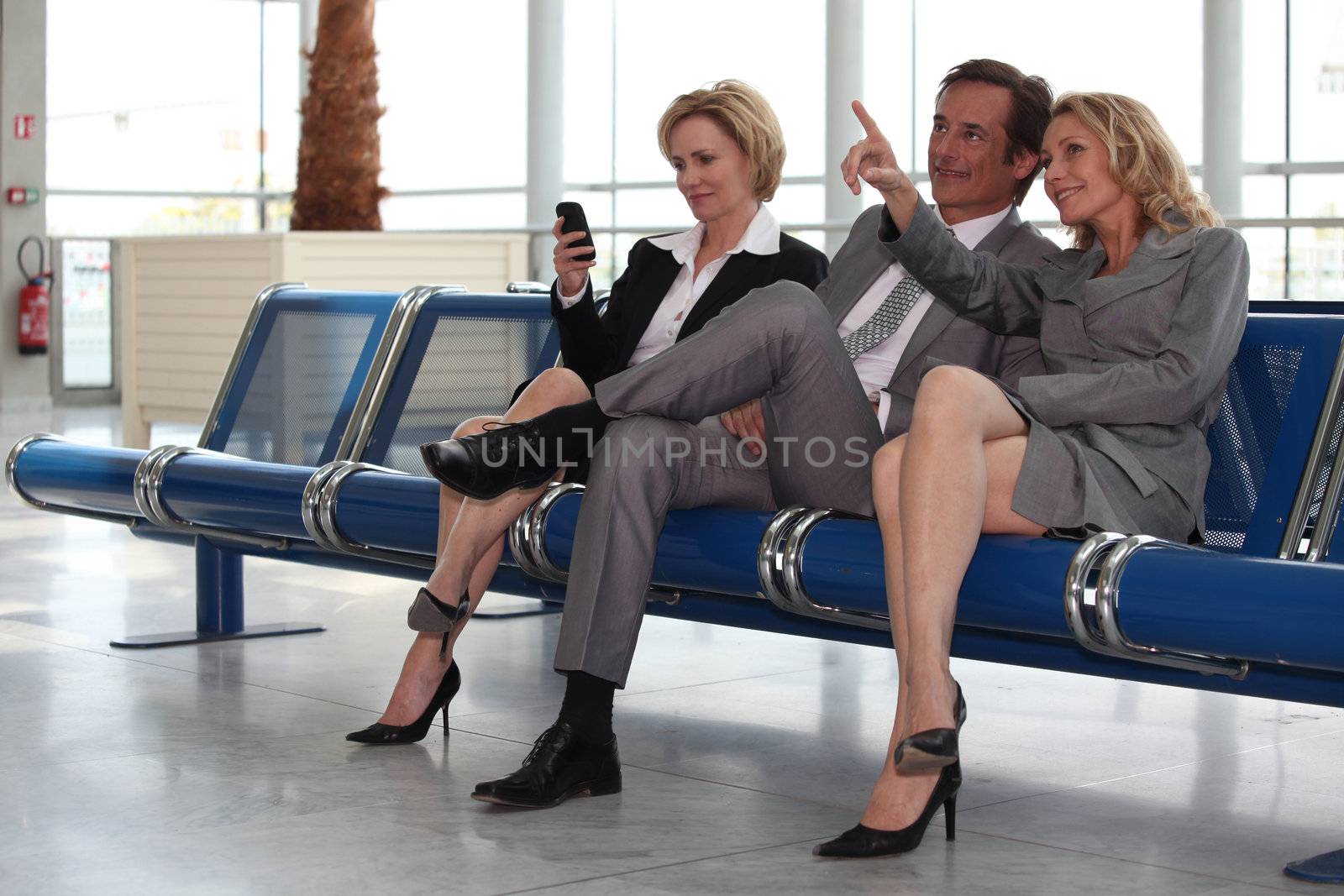 Businessmen and women in departure lounge. by phovoir