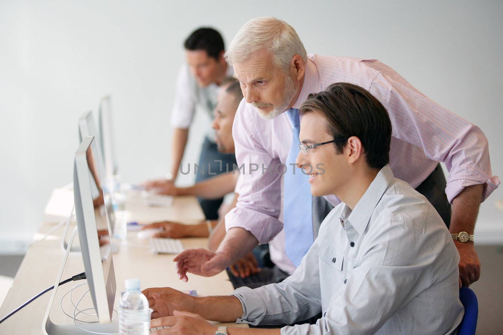 Manager in discussion with a younger worker using a computer