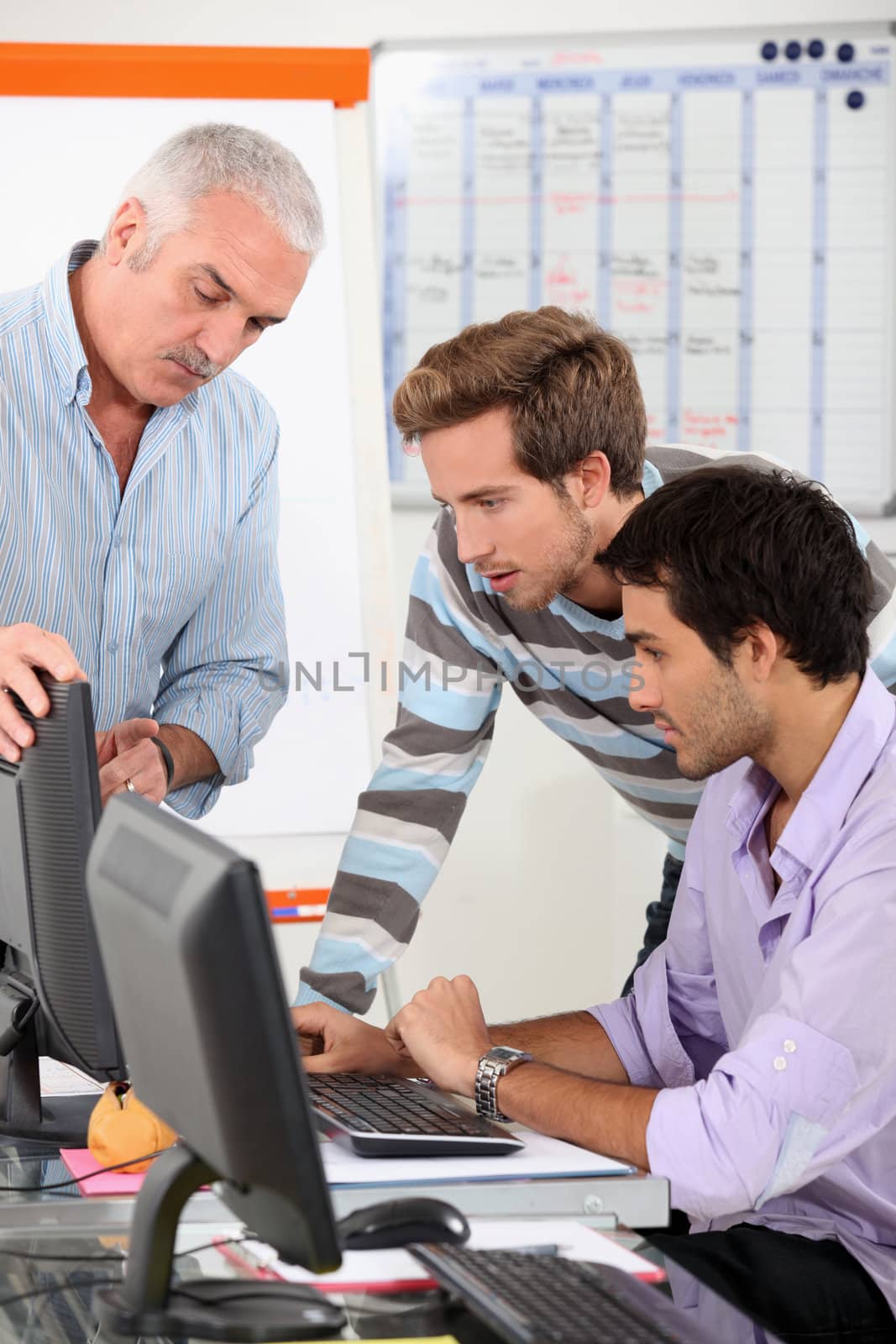 Men connecting to Internet in classroom by phovoir