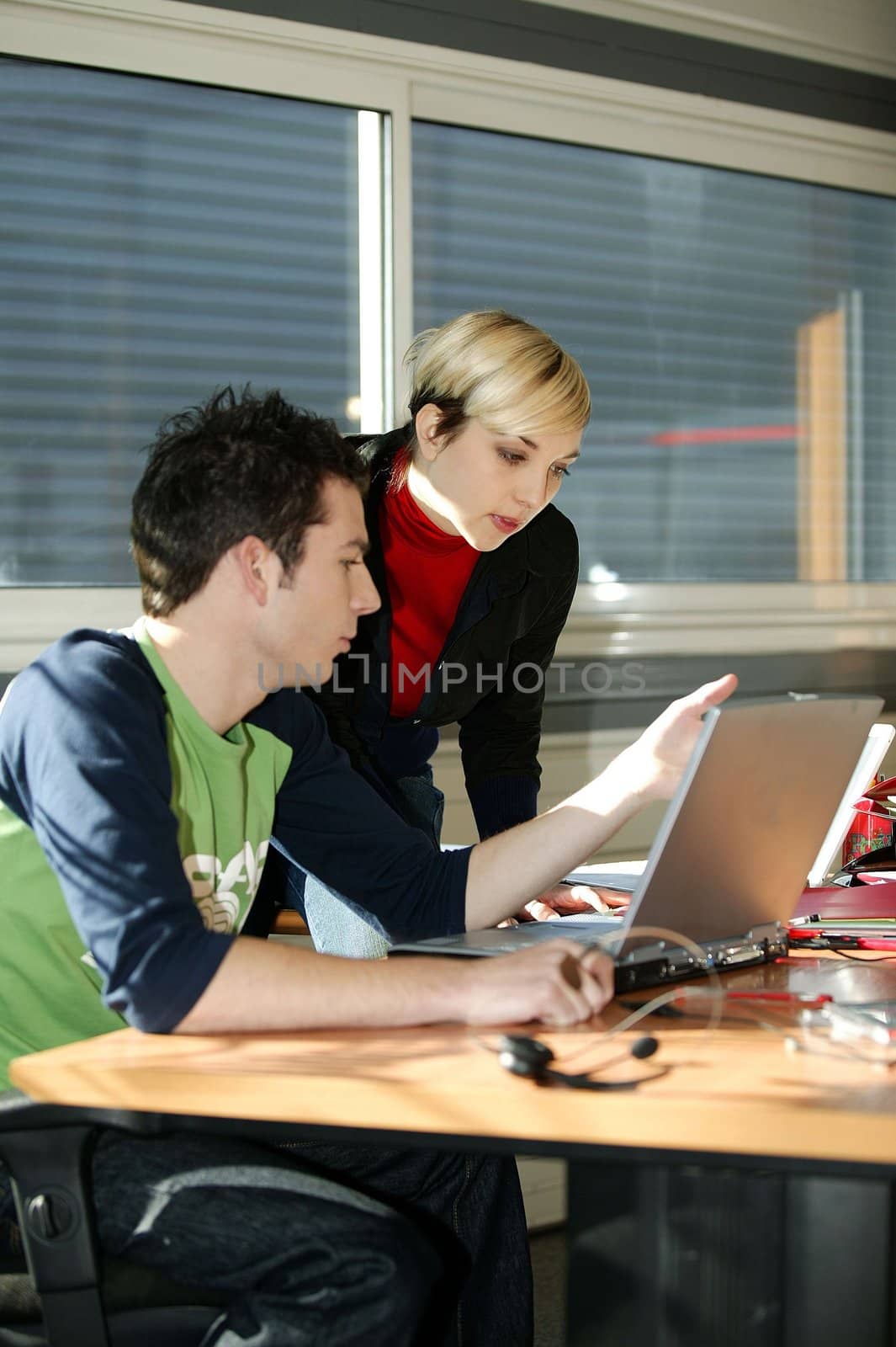 Young people at an office computer by phovoir