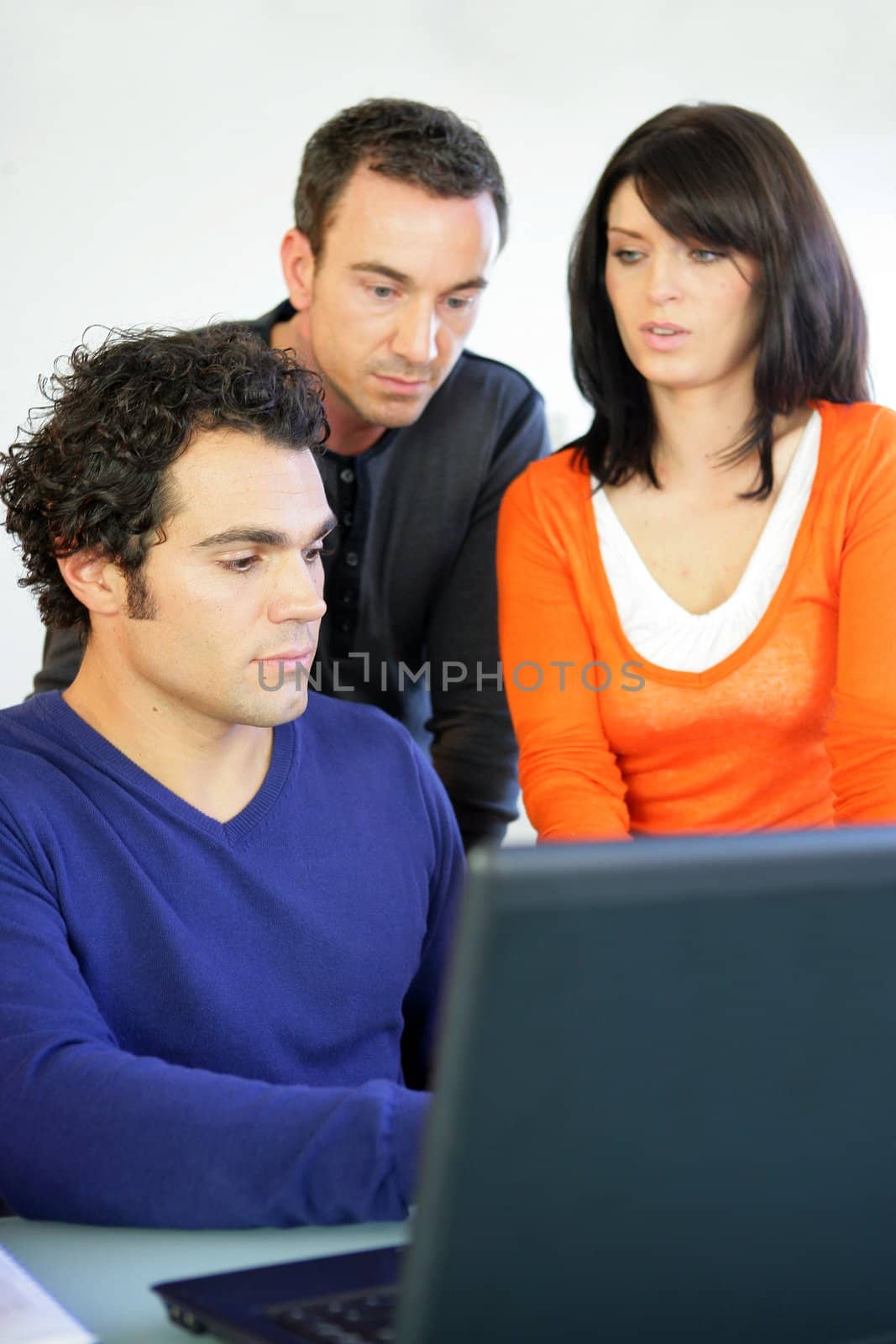 Three workers gathered around laptop