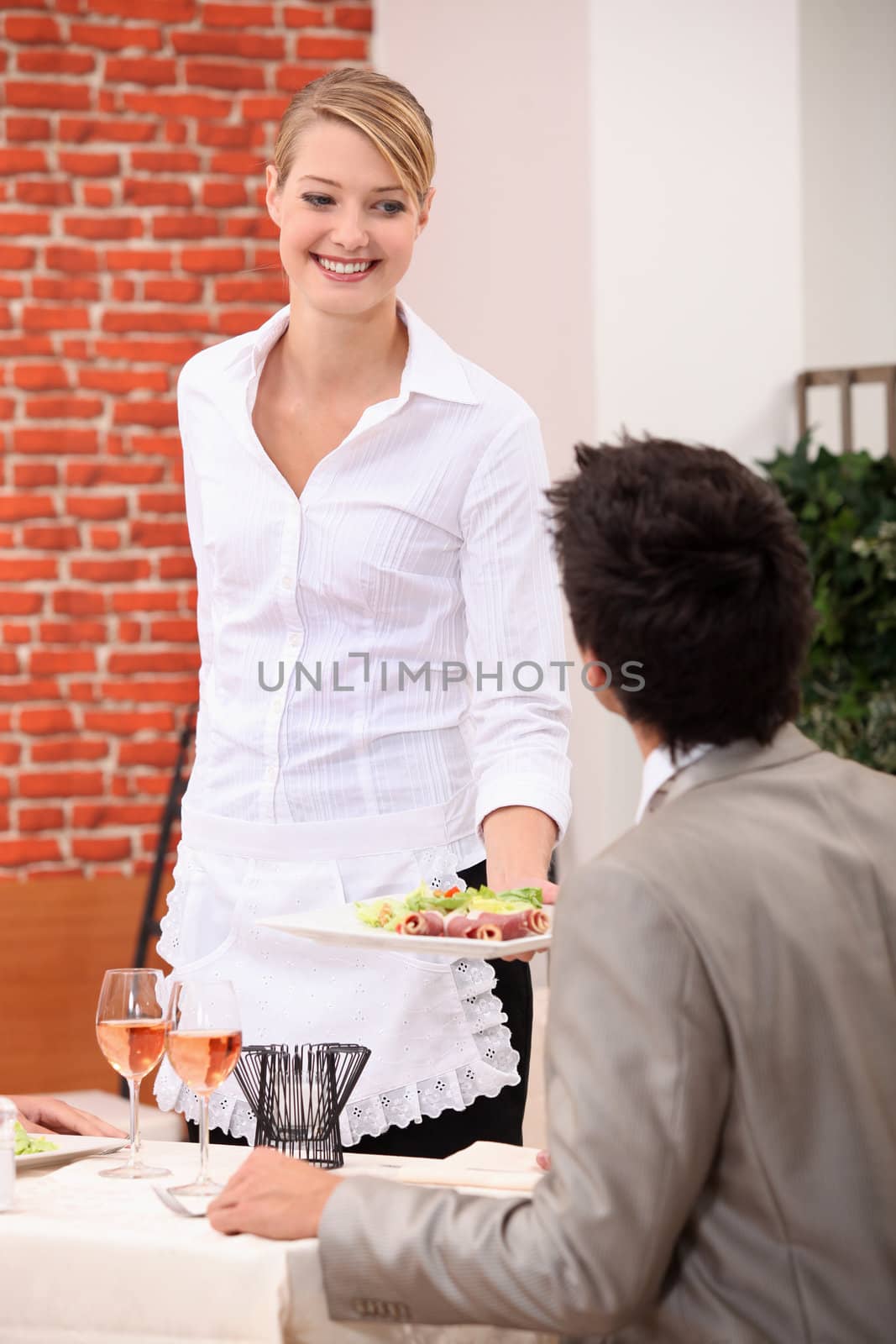 Waitress handing meal to customer by phovoir