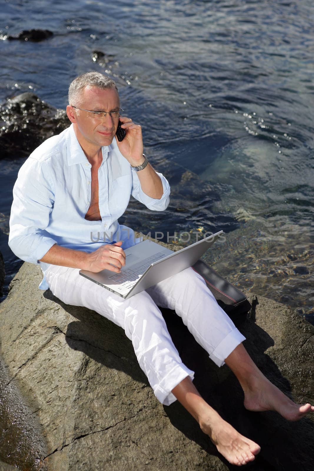 Man using his laptop by the water's edge