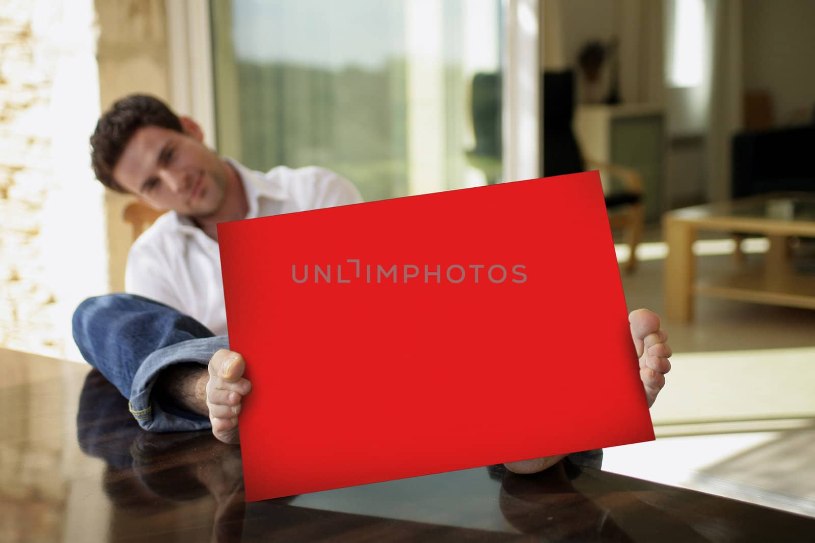 Man sat on his patio with red poster