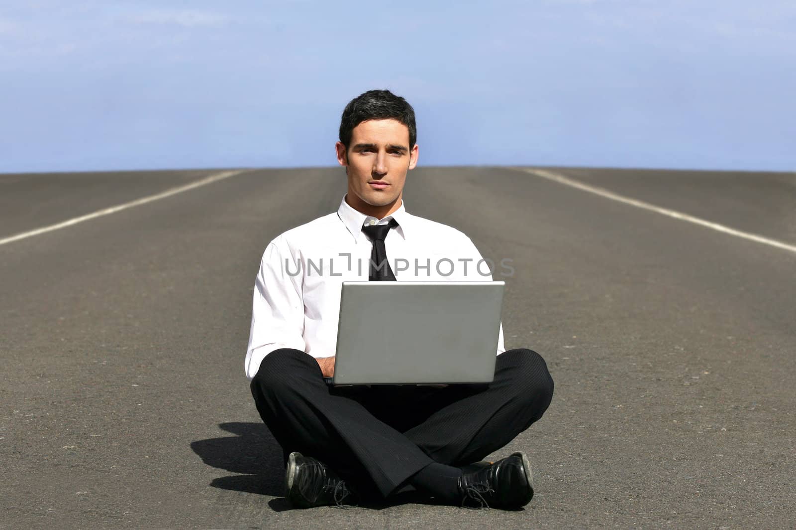 Man alone with laptop on airstrip