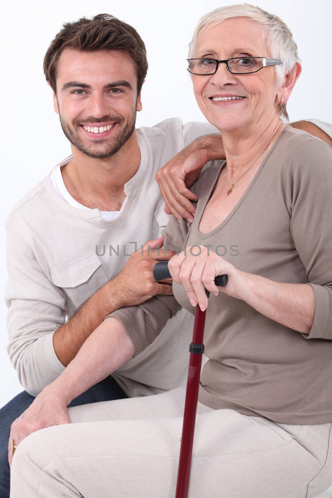 Young man crouching by elderly woman