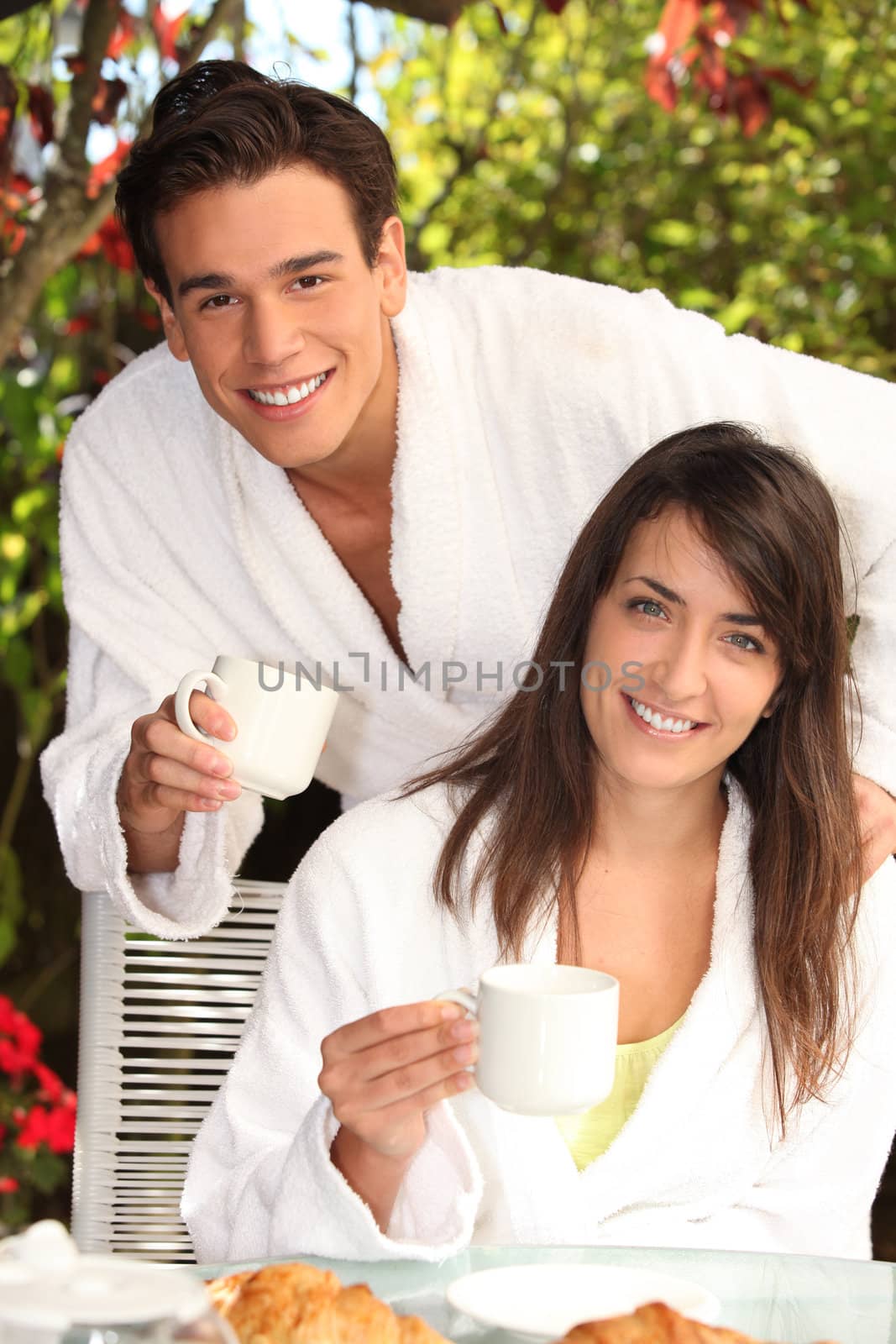 young couple having breakfast outdoors by phovoir
