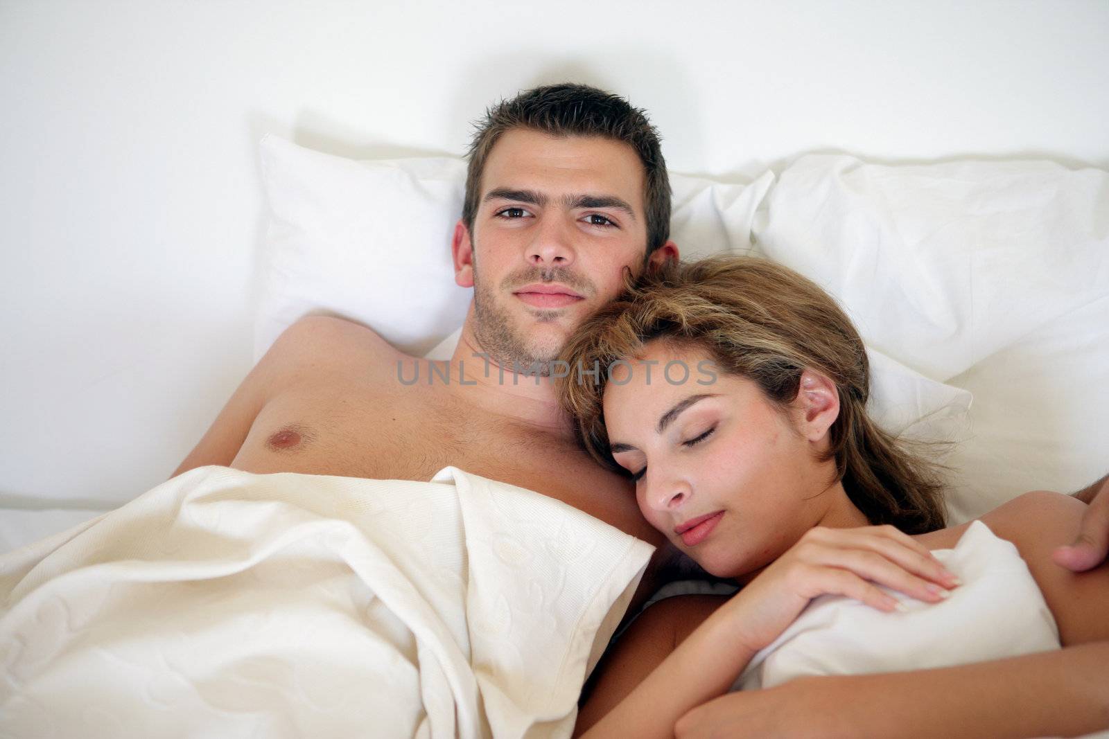 Young couple embraced in bed