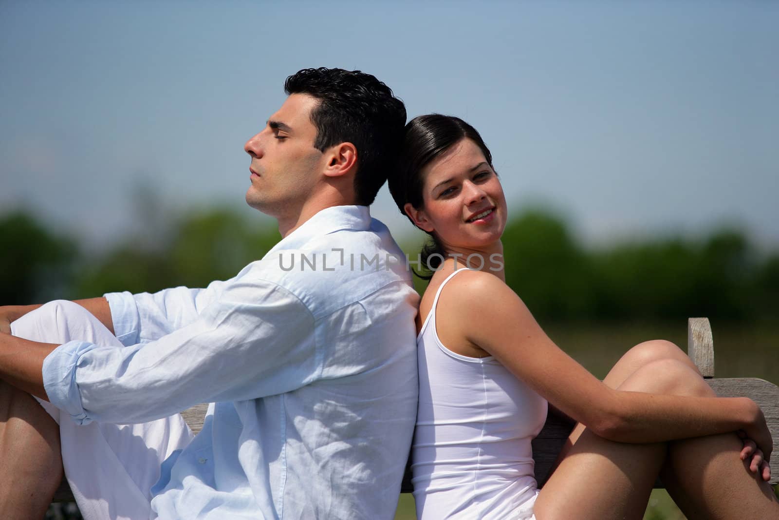 Young couple sitting in the sunshine