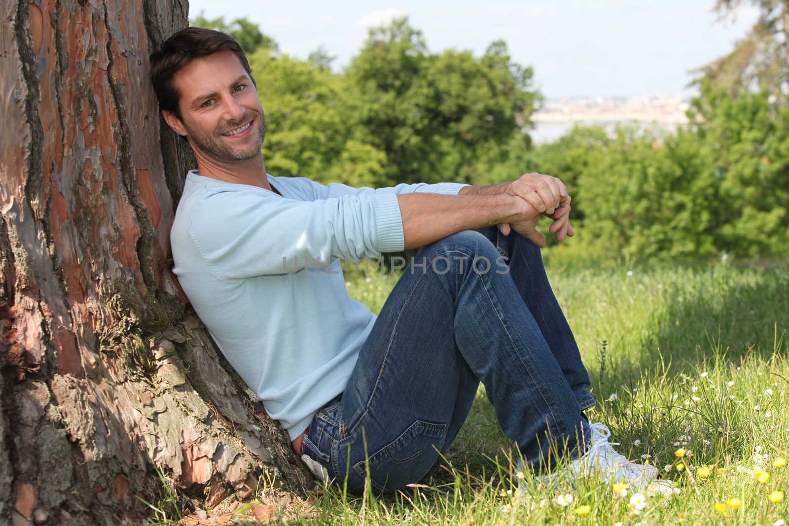 Man sitting against tree