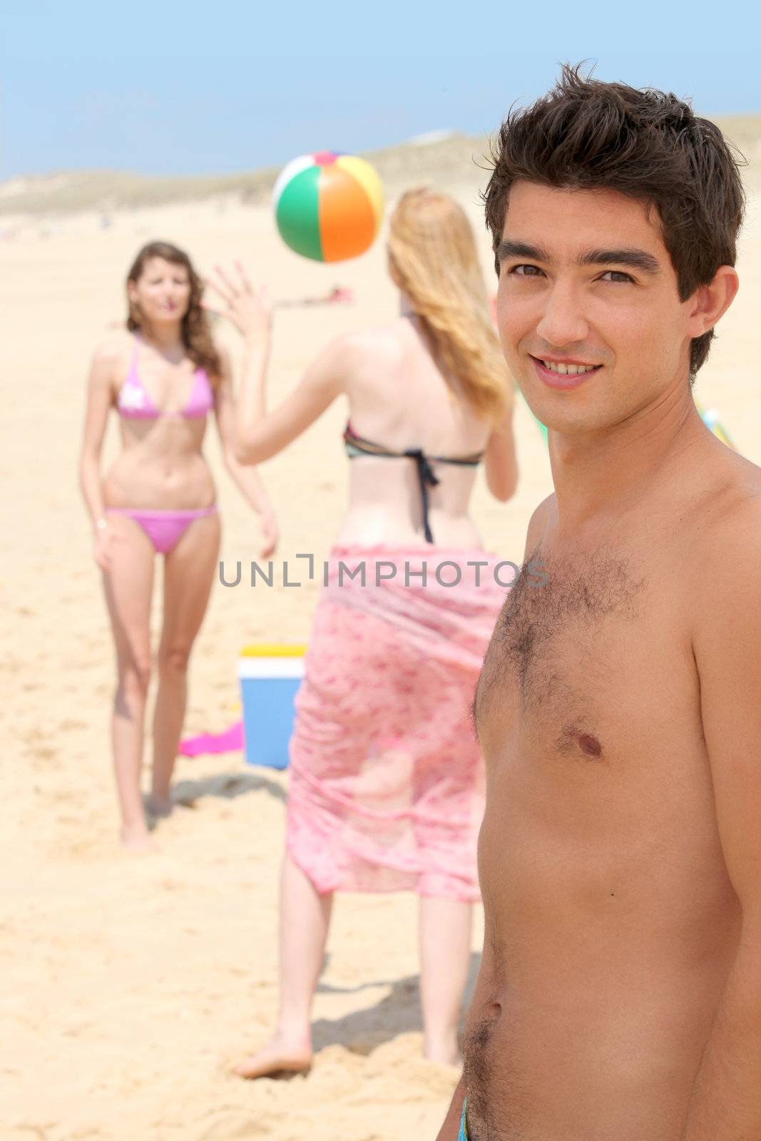 Three teenager playing with ball at the beach by phovoir