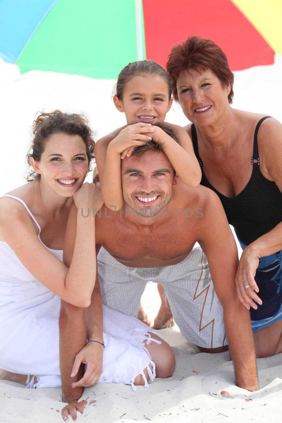 Family at the beach together by phovoir