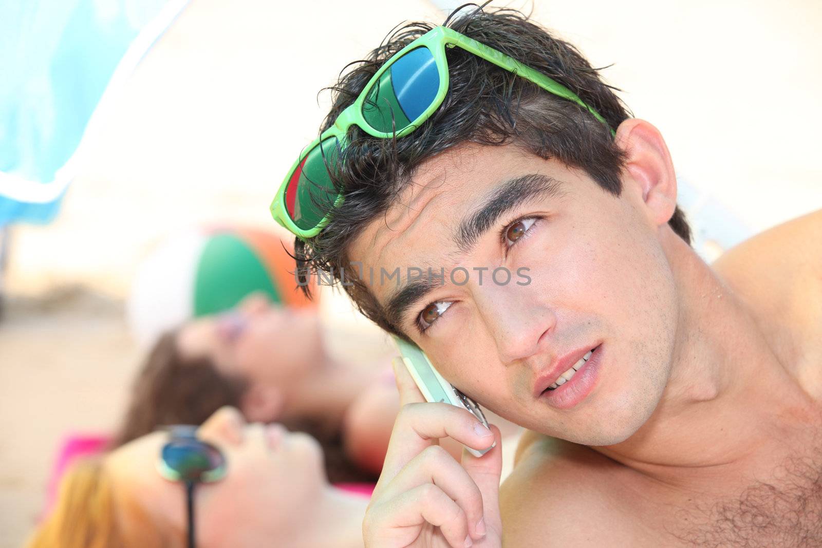 Young on the phone on the beach