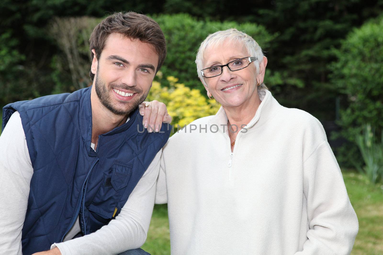 smiling young man and older woman in garden