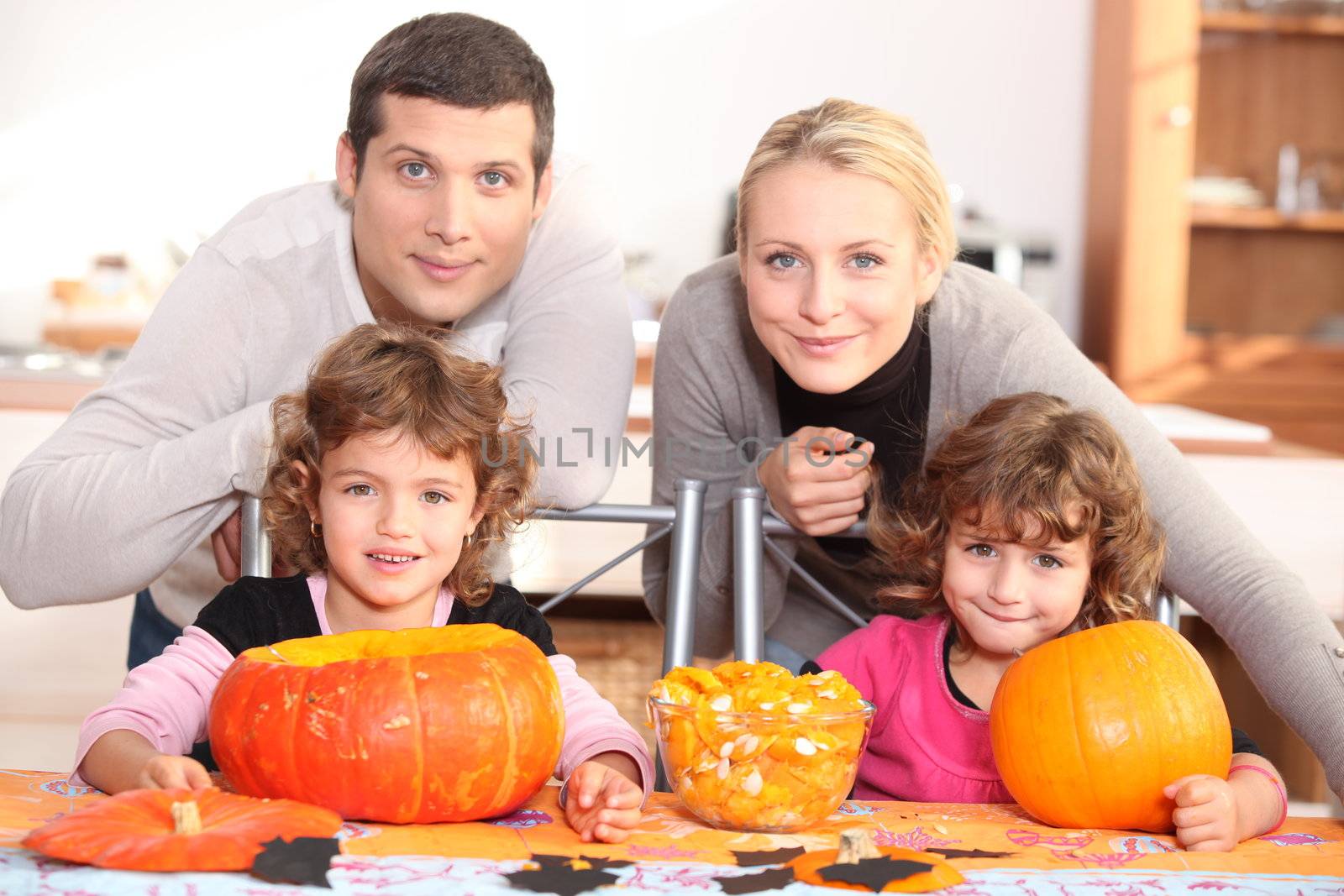 A family carving Halloween pumpkins. by phovoir