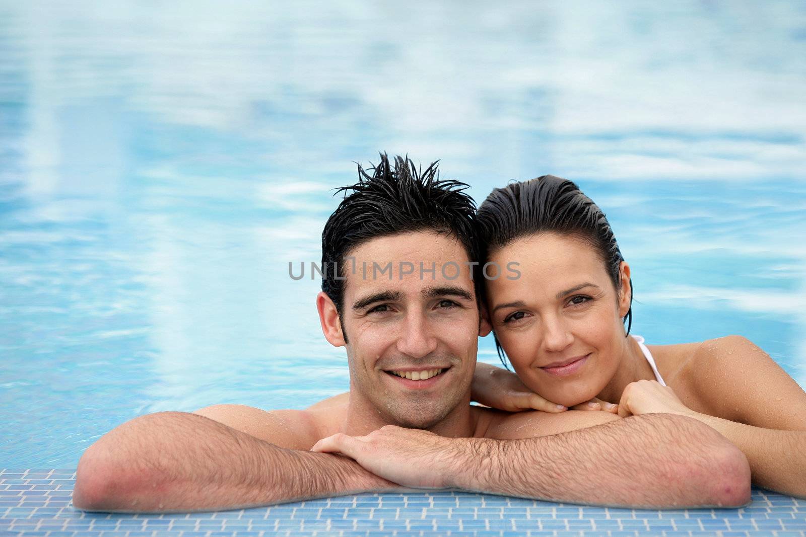 Couple stood together in swimming pool