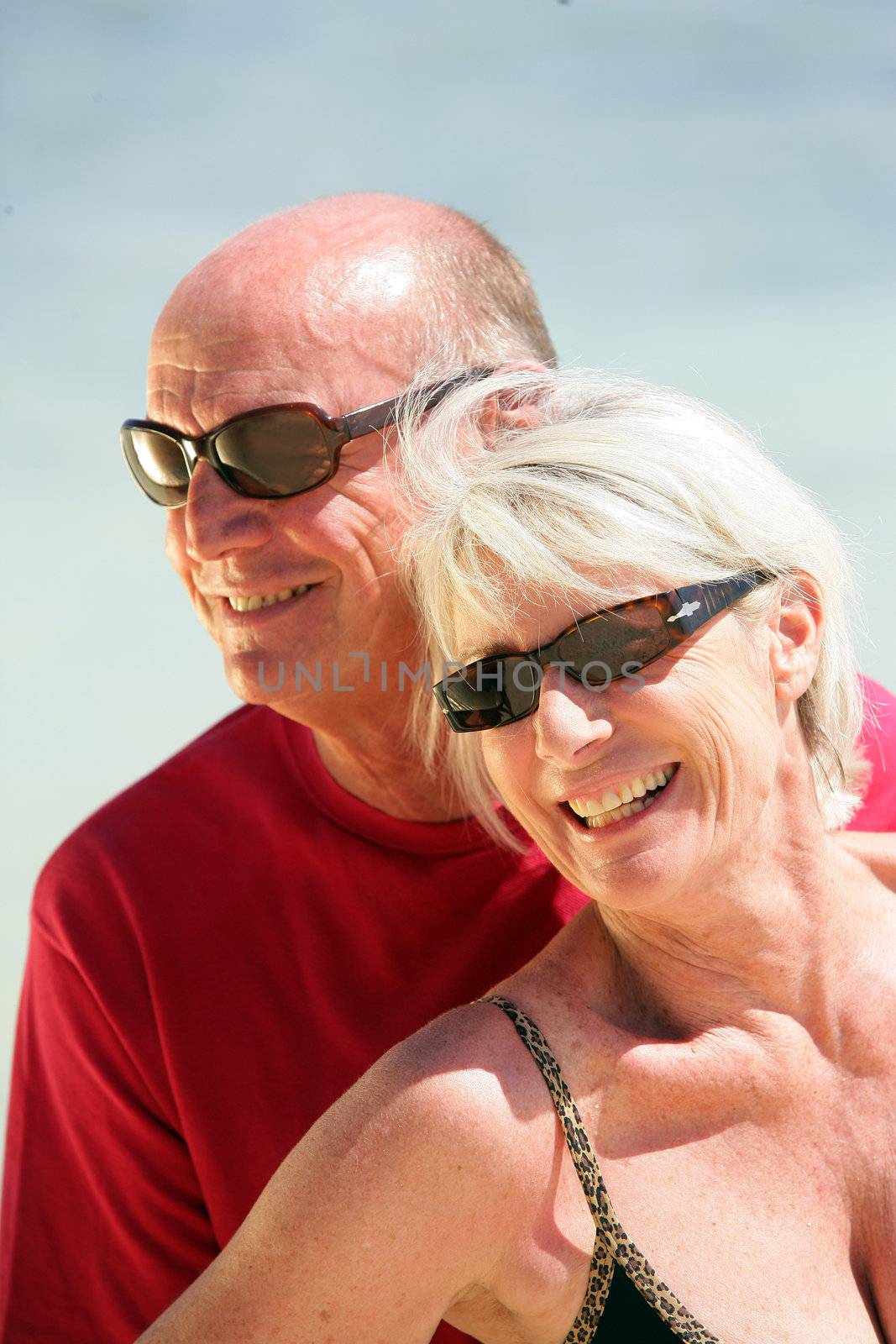 Elderly couple at the beach by phovoir